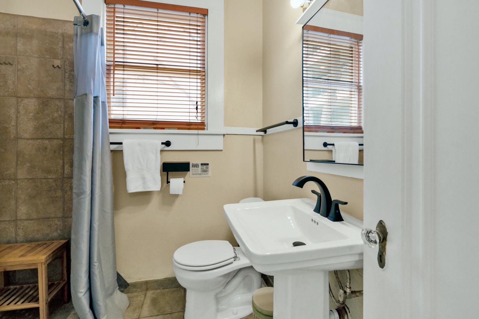 This unit’s full bathroom features a pedestal sink & walk-in shower