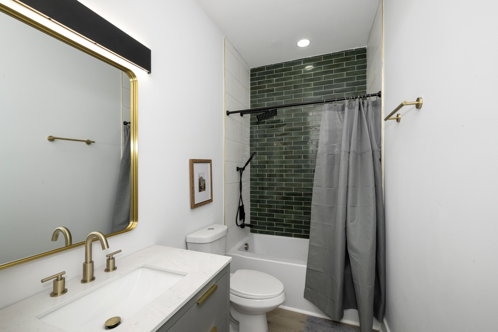 This 2nd-floor full bath showcases a single vanity & tiled shower/tub combo