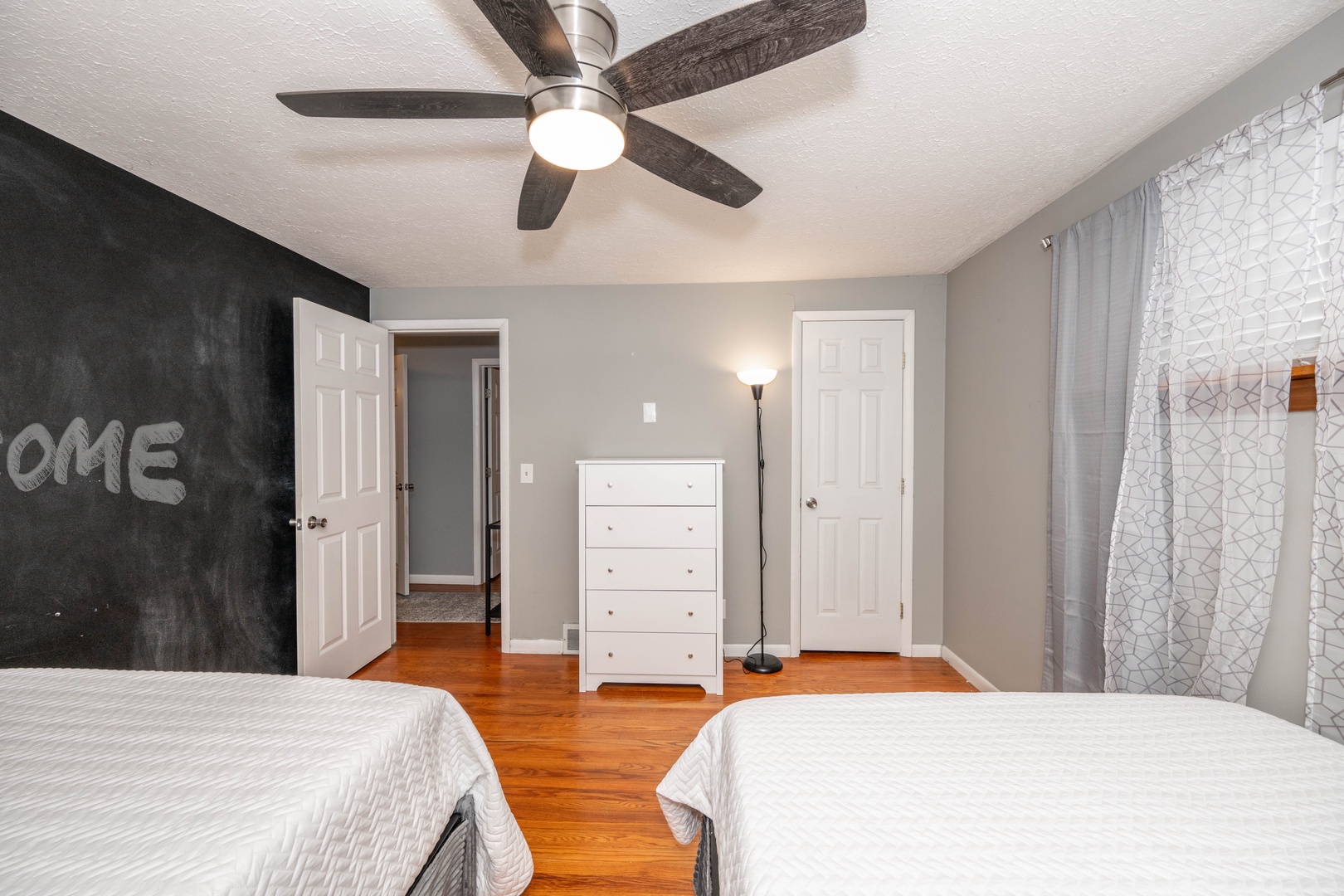 The final bedroom includes a pair of cozy full-sized beds & ceiling fan