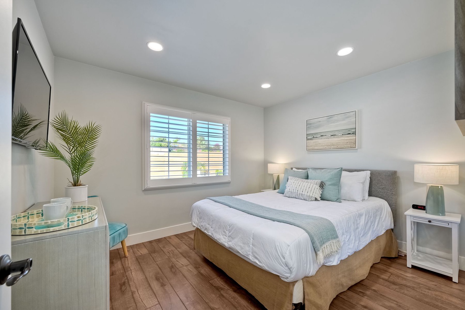 The tranquil second bedroom offers a comfy queen bed & Smart TV