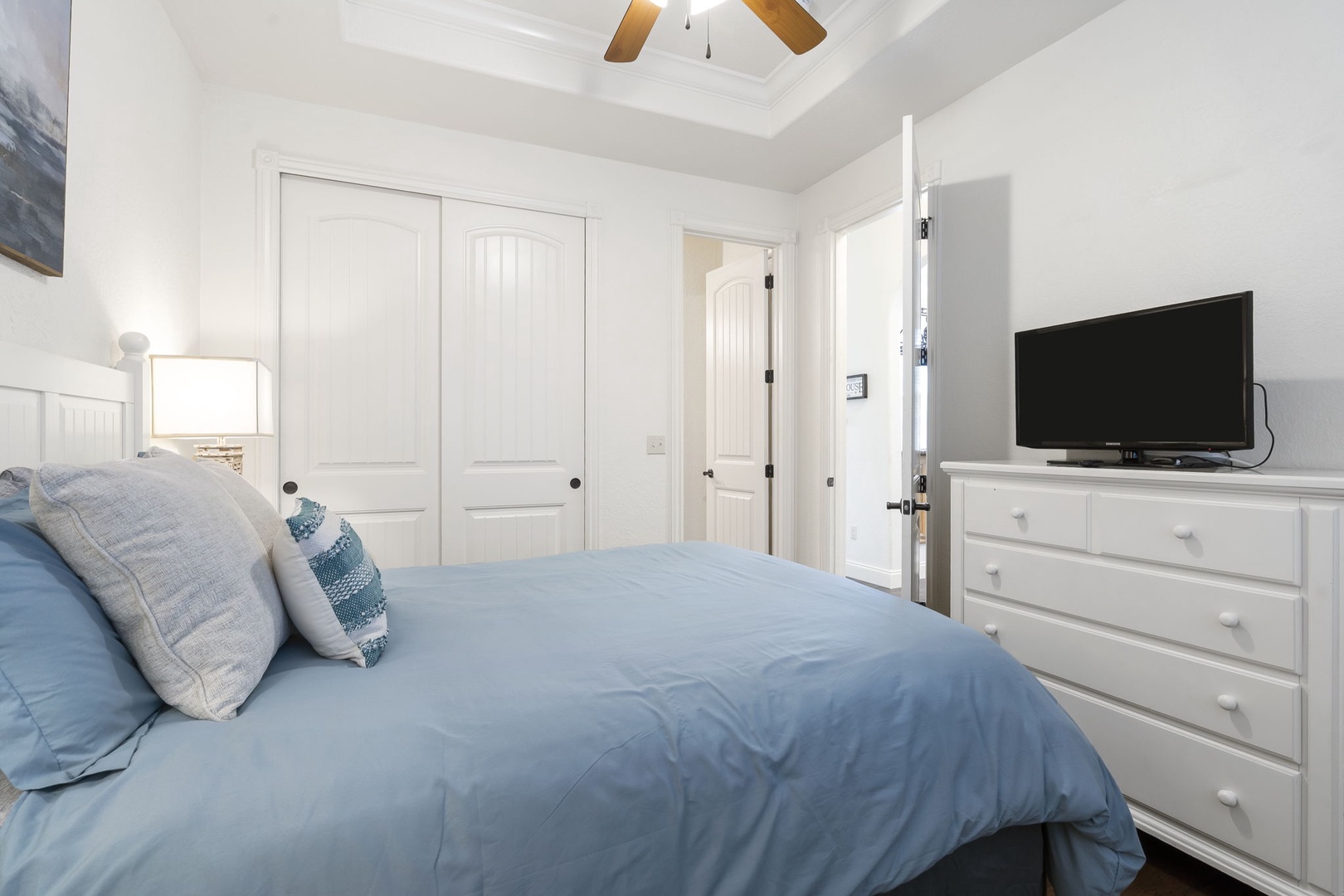 The queen suite offers a private en suite, ceiling fan, & Smart TV