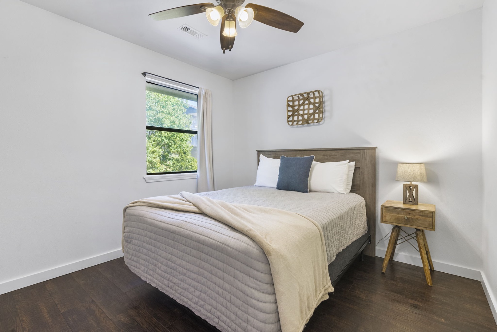 This serene bedroom offers a queen bed & ceiling fan