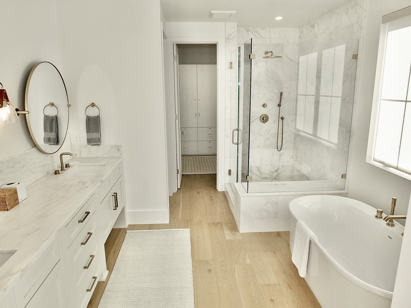 This ensuite features a dual vanity, glass shower, & luxe soaking tub