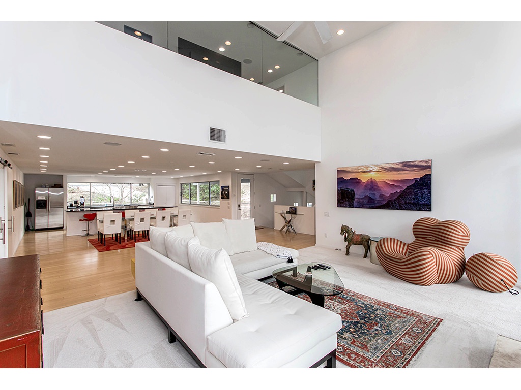 Mid level living room with TV, and large glass windows