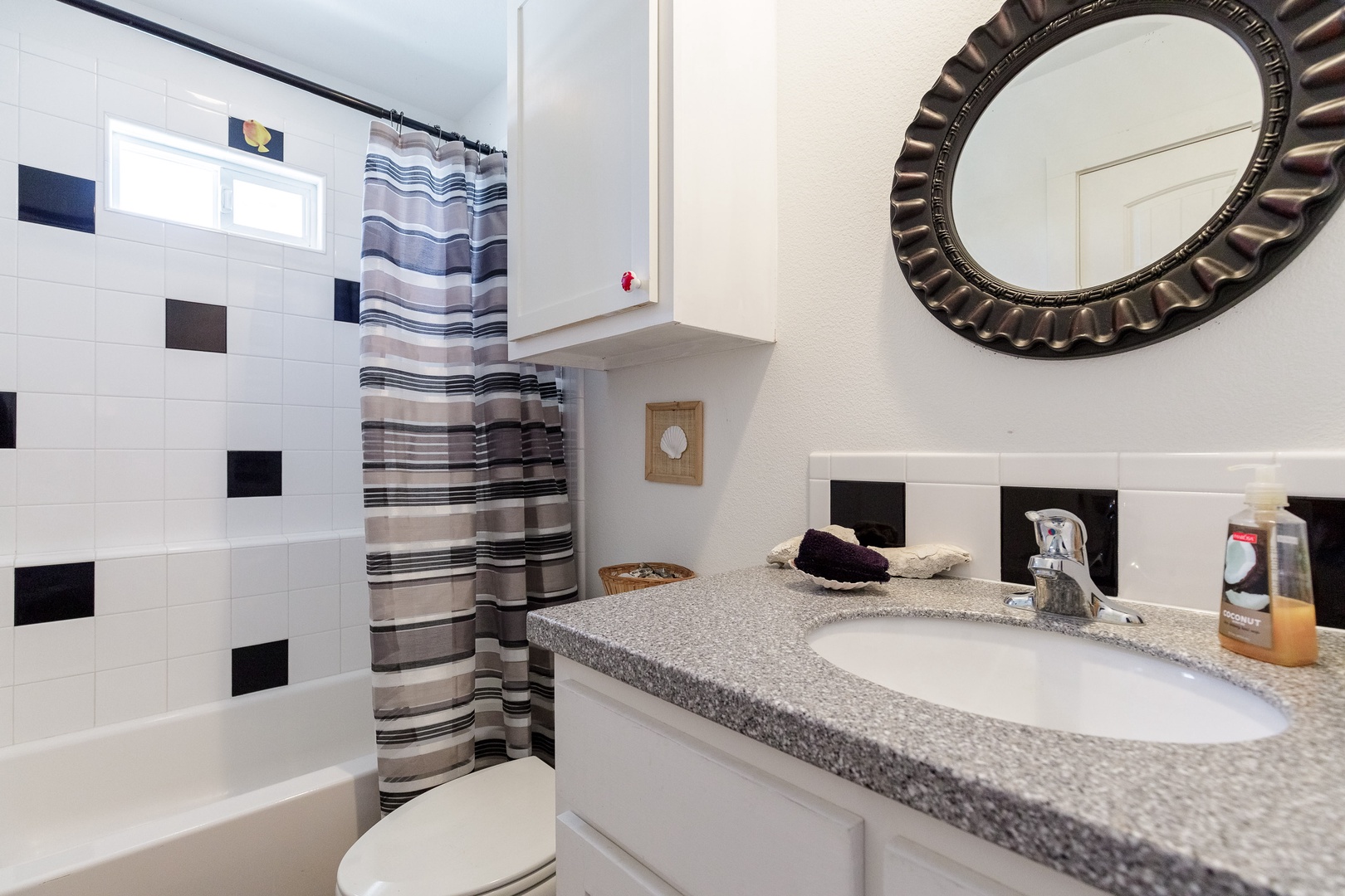 This en suite full bath offers a single vanity & shower/tub combo
