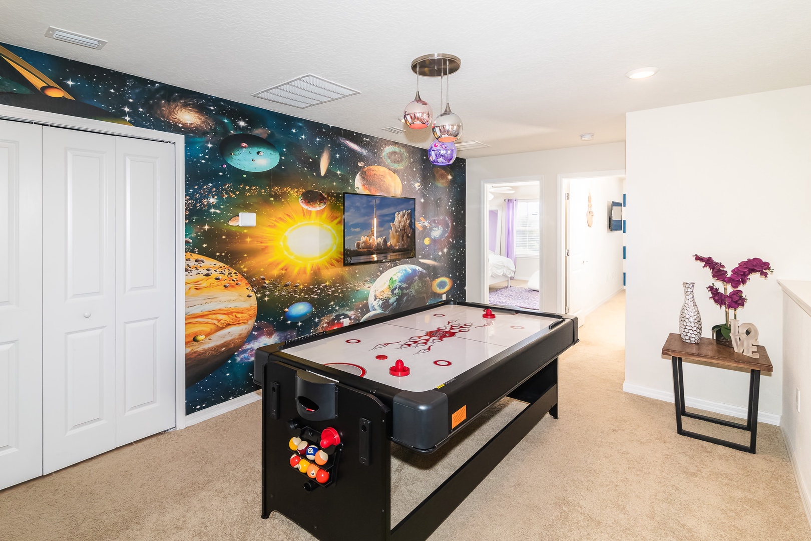 Game room on 2nd floor landing with air hockey table and TV