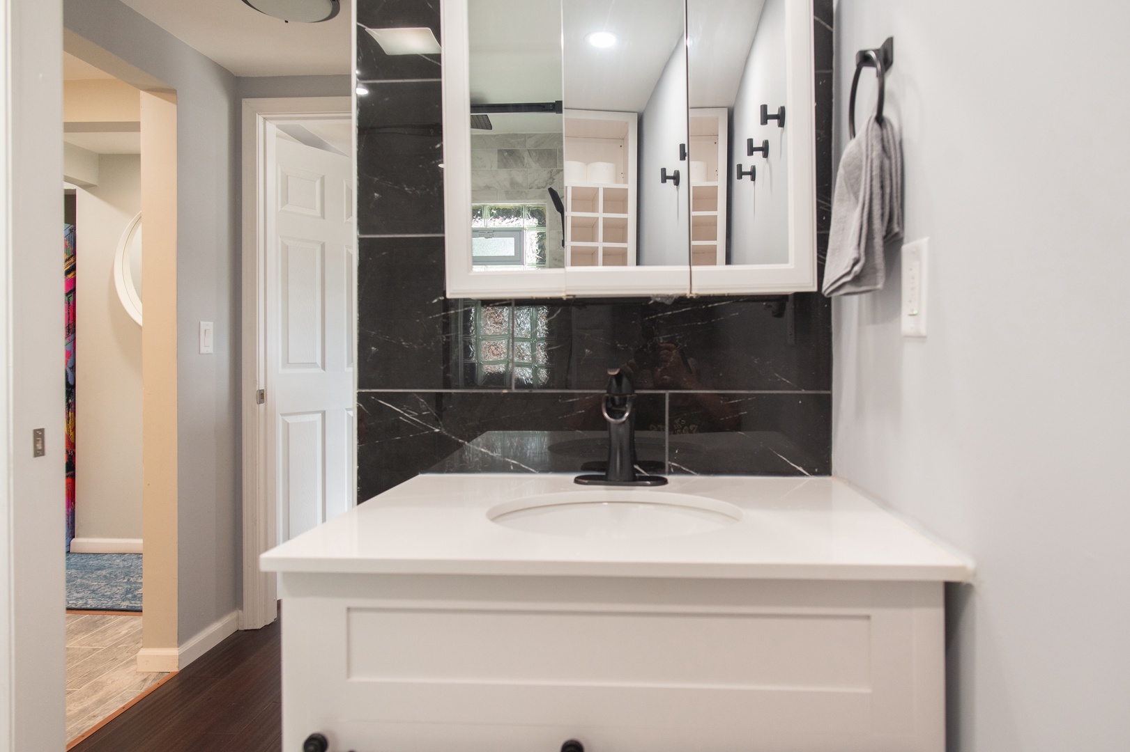 The apartment’s full bathroom offers a single vanity & glass shower