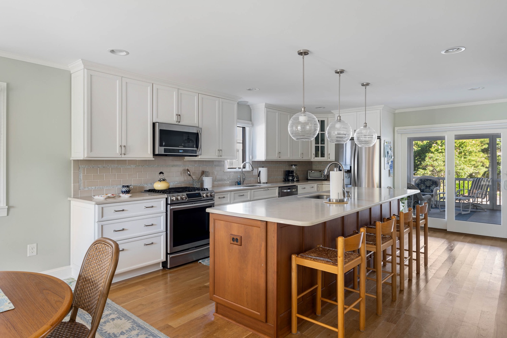 A gorgeous, open kitchen with beautiful amenities, ample storage, and counter seating for 4
