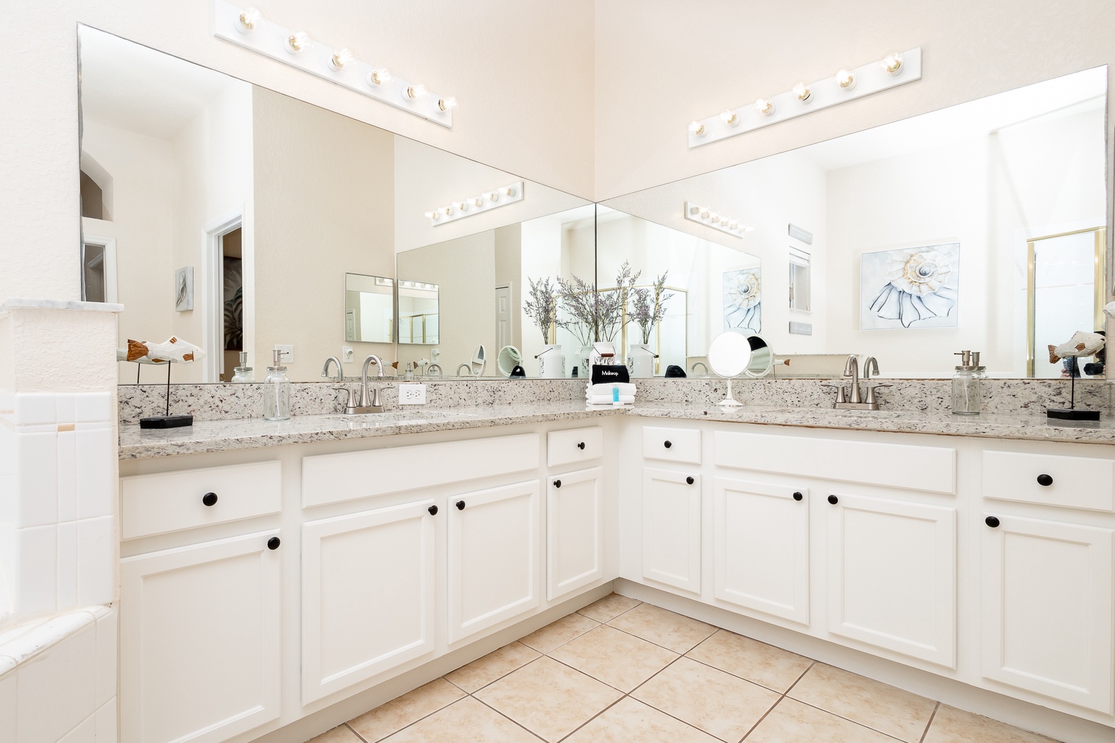 The king ensuite features dual vanities, a glass shower, & luxurious soaking tub