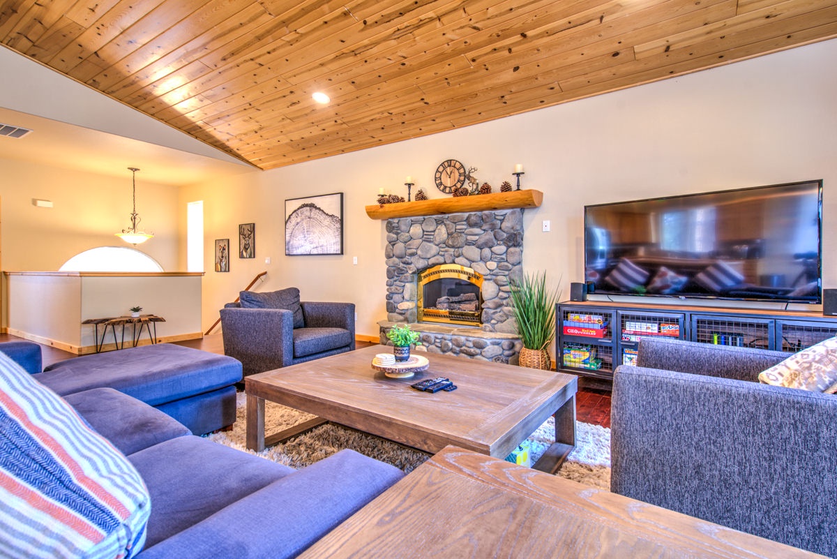 Open living space with fire place, TV, and deck