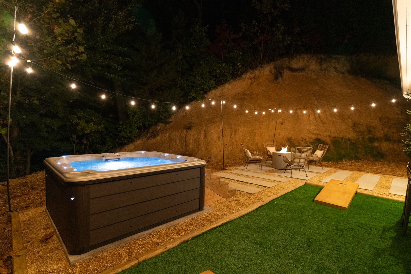 Backyard oasis with firepit, hot tub, bar seating, and cornhole for fun evenings