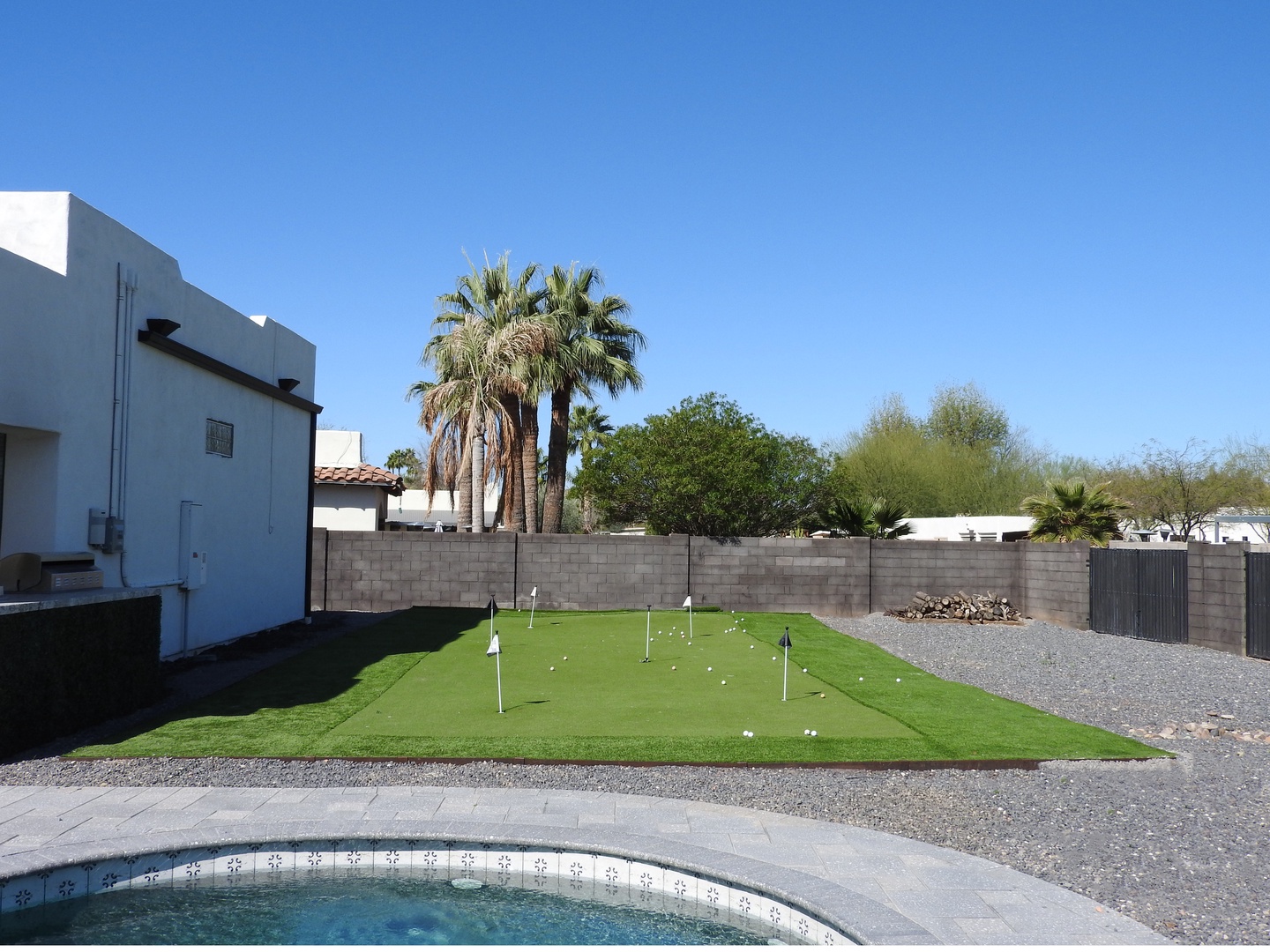 Savor the backyard oasis with pool, basketball court and putting green