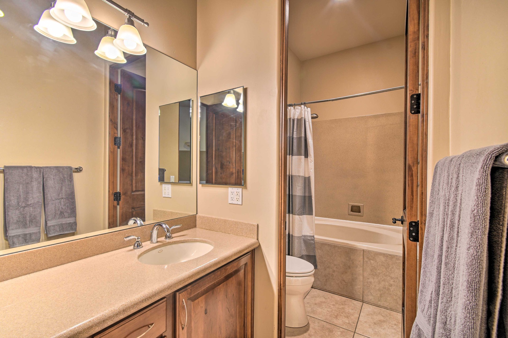 This shared full bath offers a large vanity & shower/tub combo