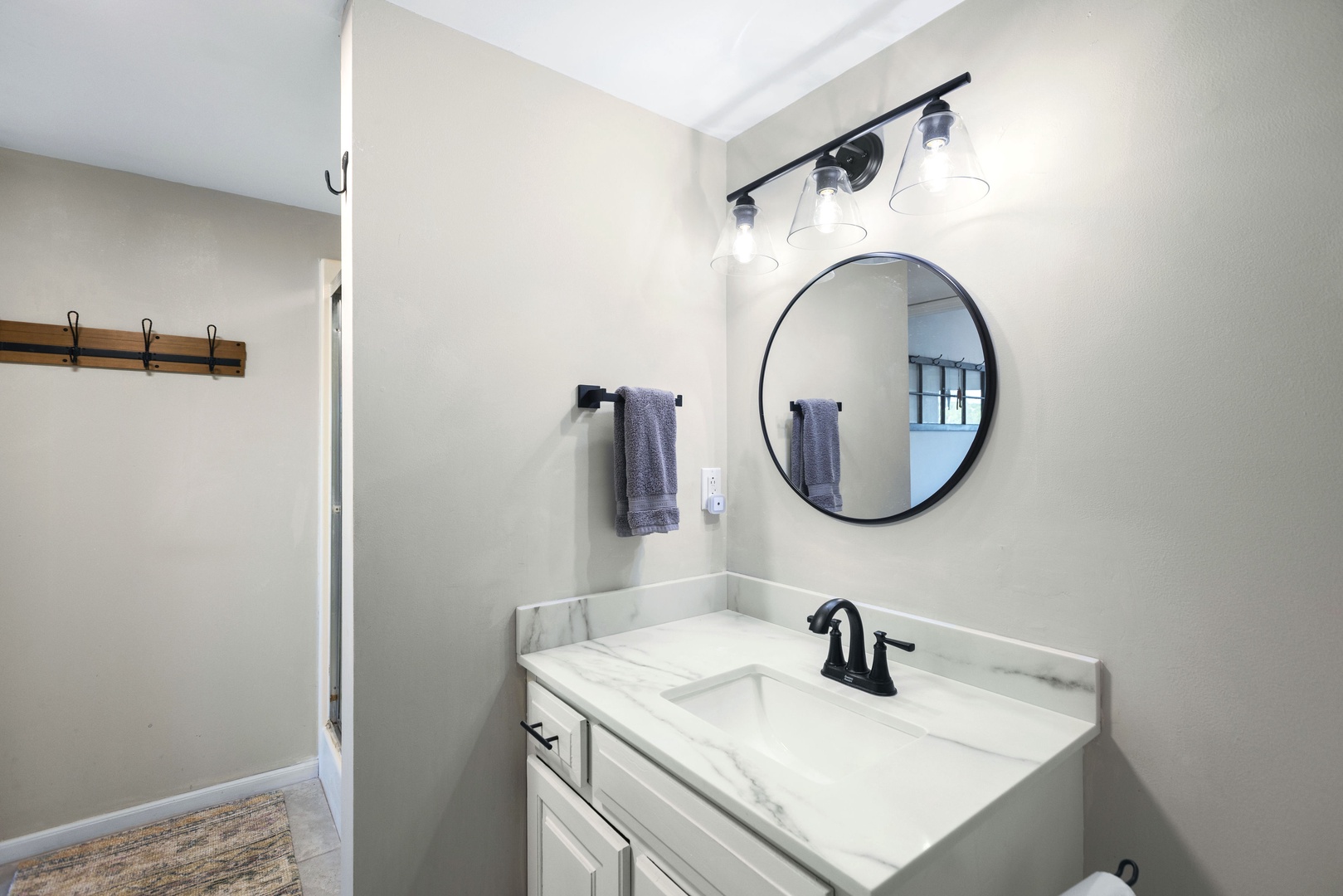 This lower-level full bath includes a single vanity, shower, & private laundry