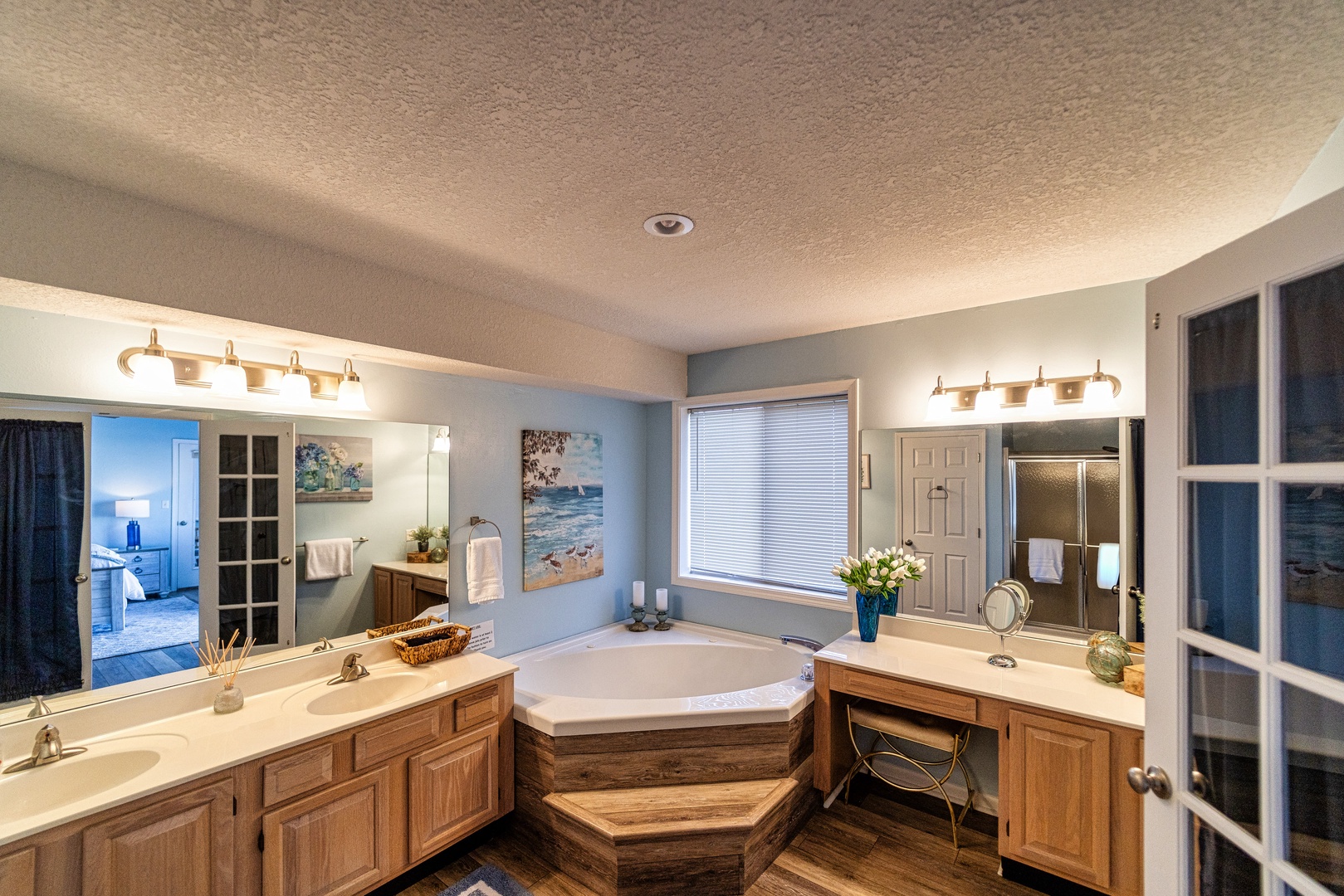 Bathroom private en-suite with soaking tub, dual sinks, vanity, and stand up shower