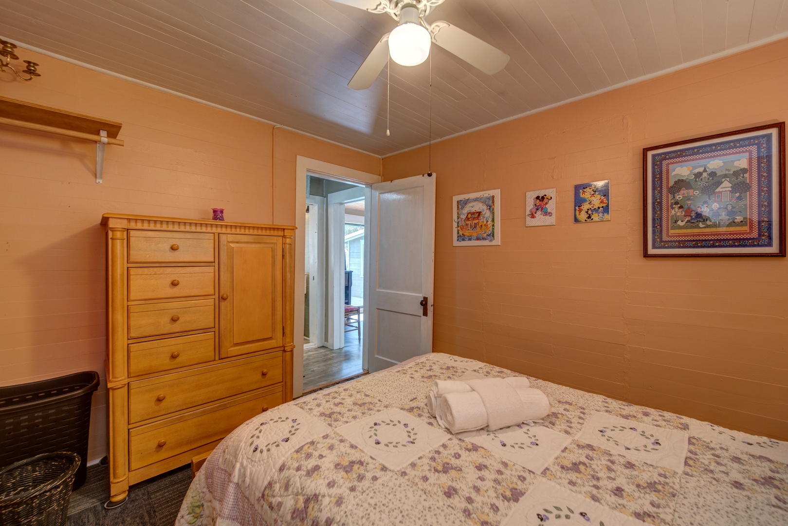 The 1st of 3 bedrooms offers a cozy queen bed & ceiling fan
