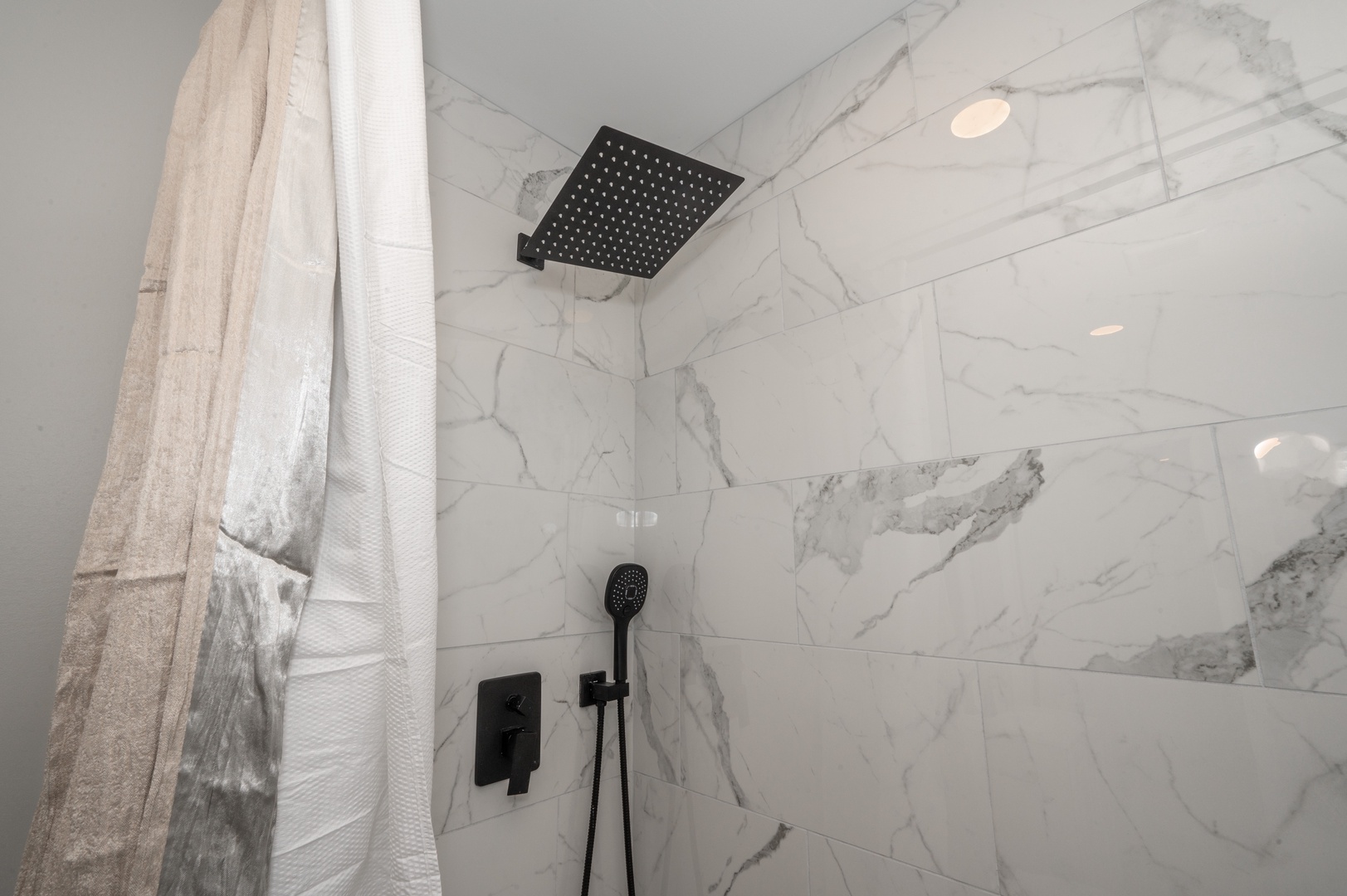 Apt 2 – The full bathroom offers guests a single vanity & walk-in shower