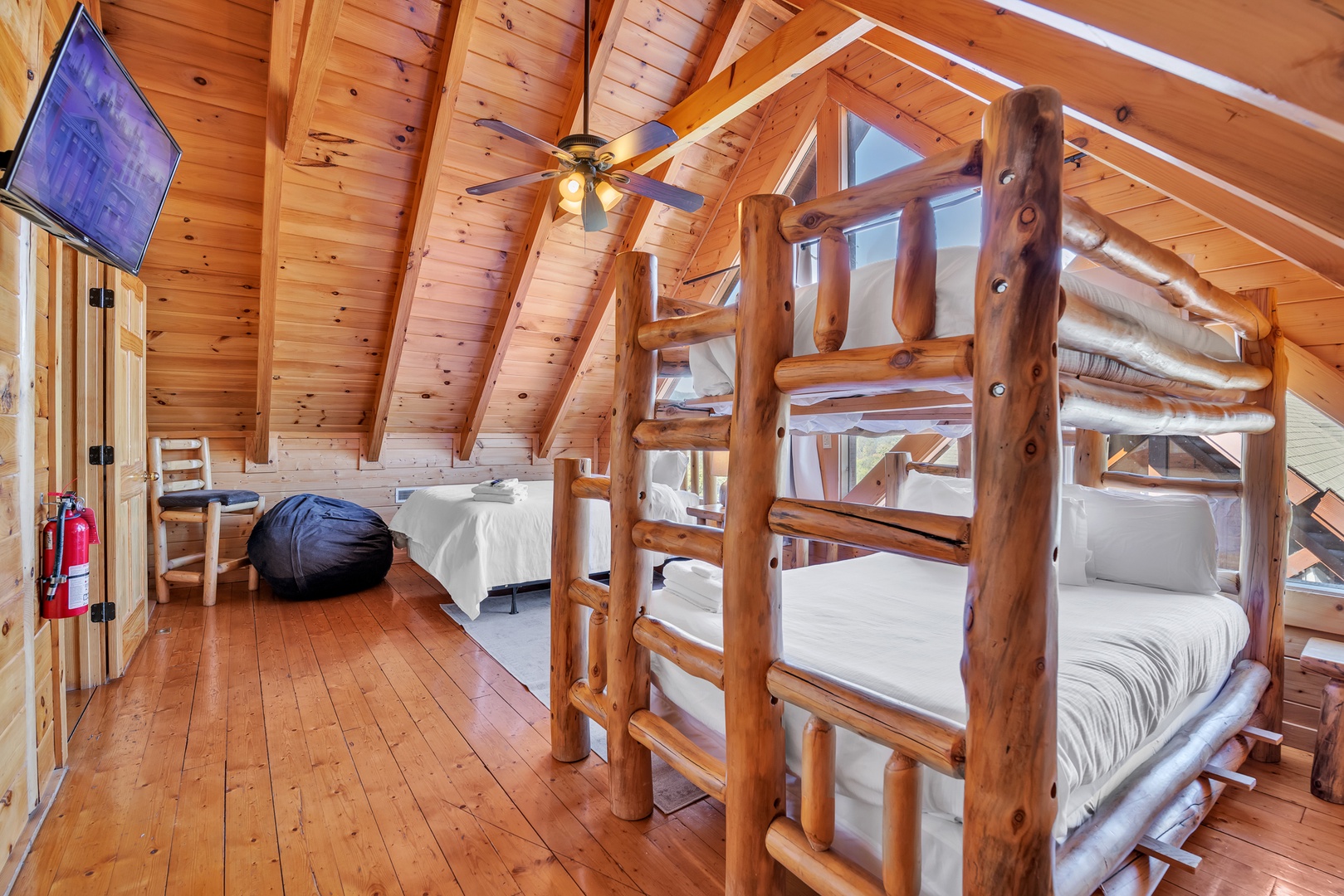 This 4th floor bedroom includes a TV, queen bed, & twin-over-queen bunkbed