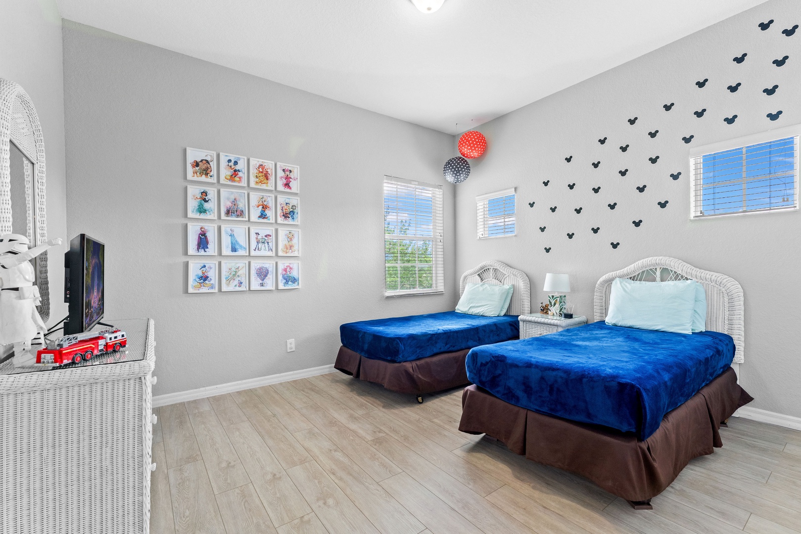 Room with 2 twin beds, decorated with fun Disney-themed decals and accents