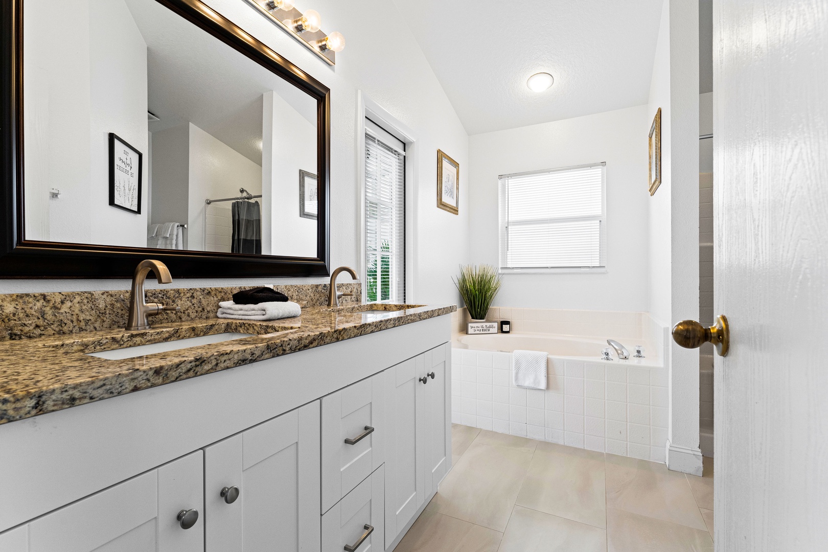 The king ensuite features a double vanity, shower, & luxe soaking tub