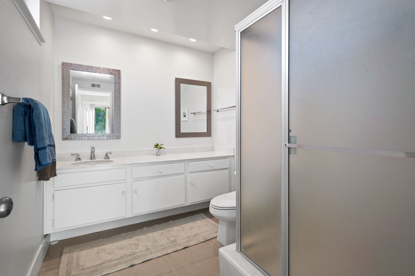 The king en suite boasts a spacious oversized vanity & glass shower