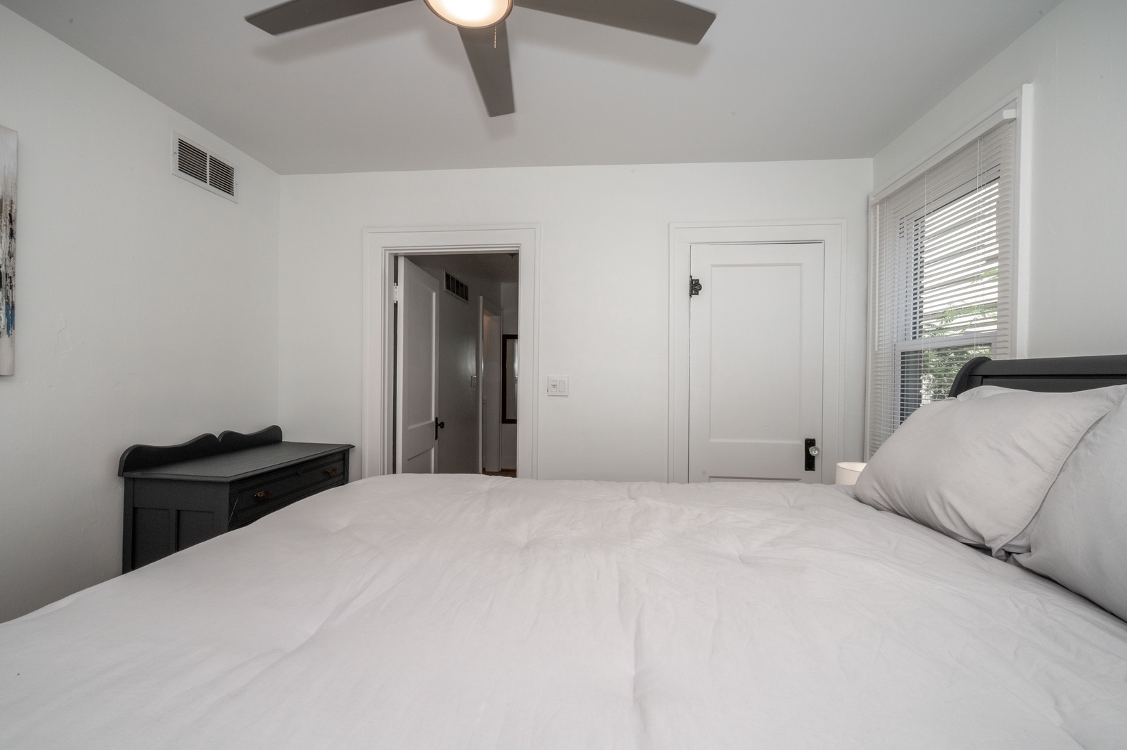 The tranquil queen bedroom includes a ceiling fan & standing mirror