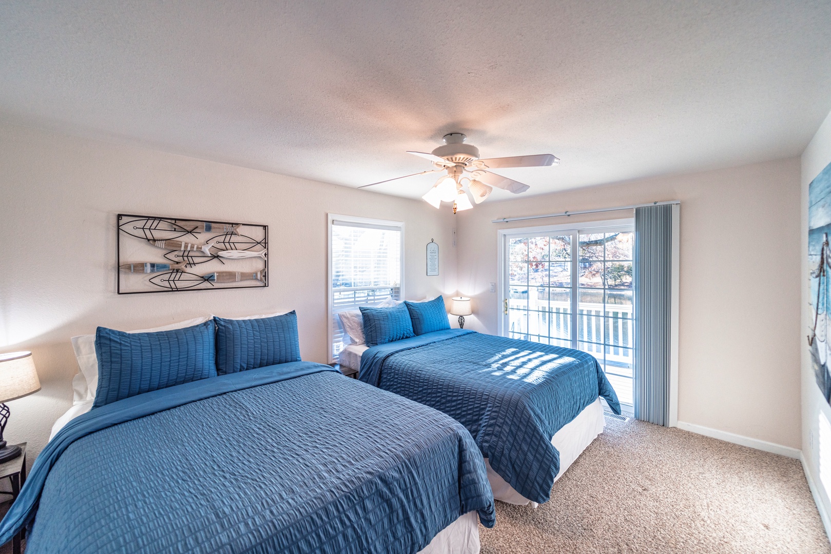 The second upper-level bedroom offers a pair of queen beds & deck access
