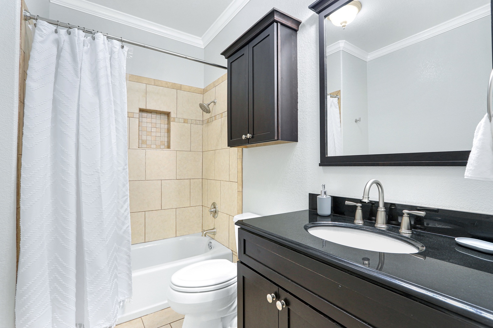 This ensuite bath offers a sleek single vanity & shower/tub combo