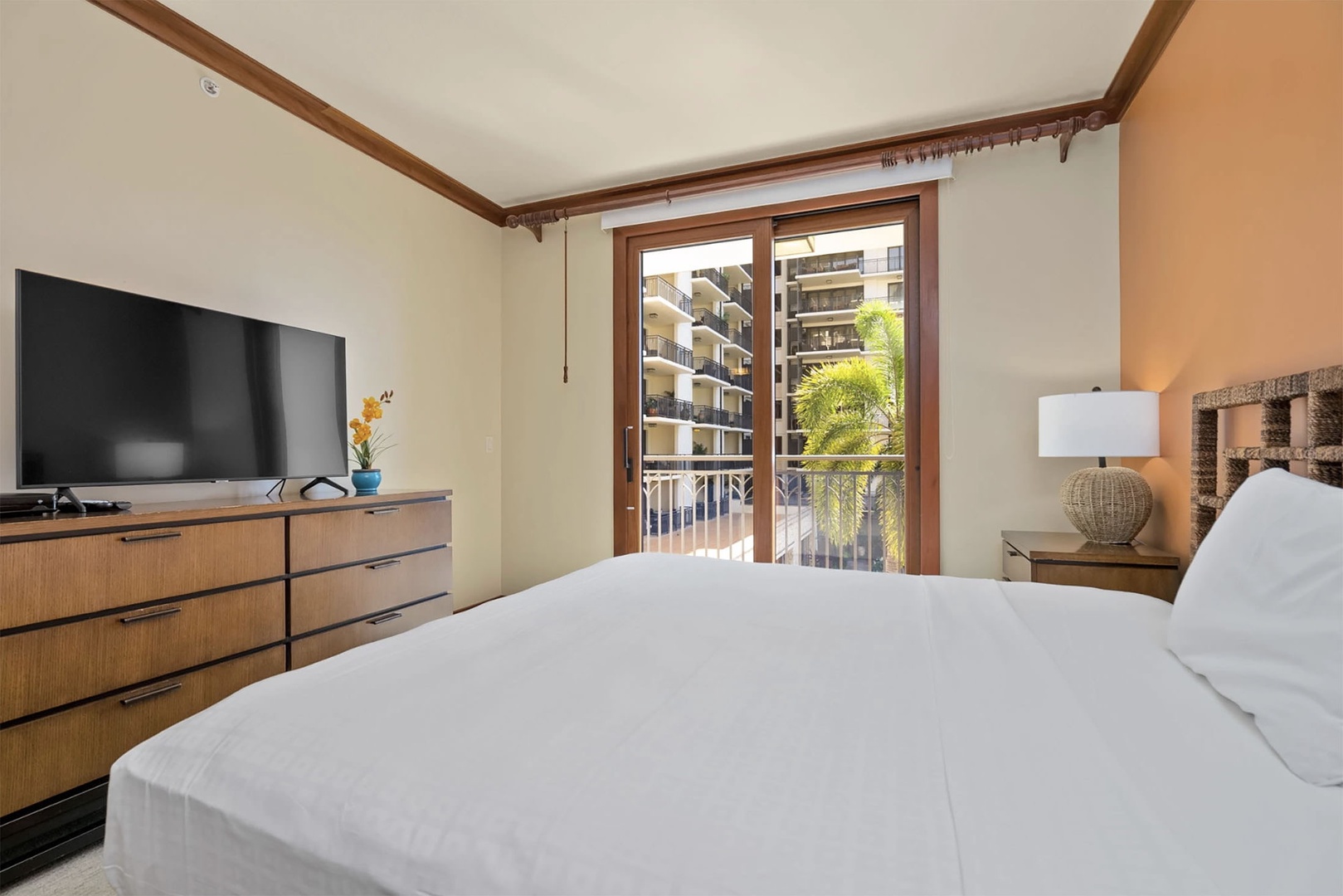 Primary bedroom features a king bed, balcony, ensuite bathroom, and TV