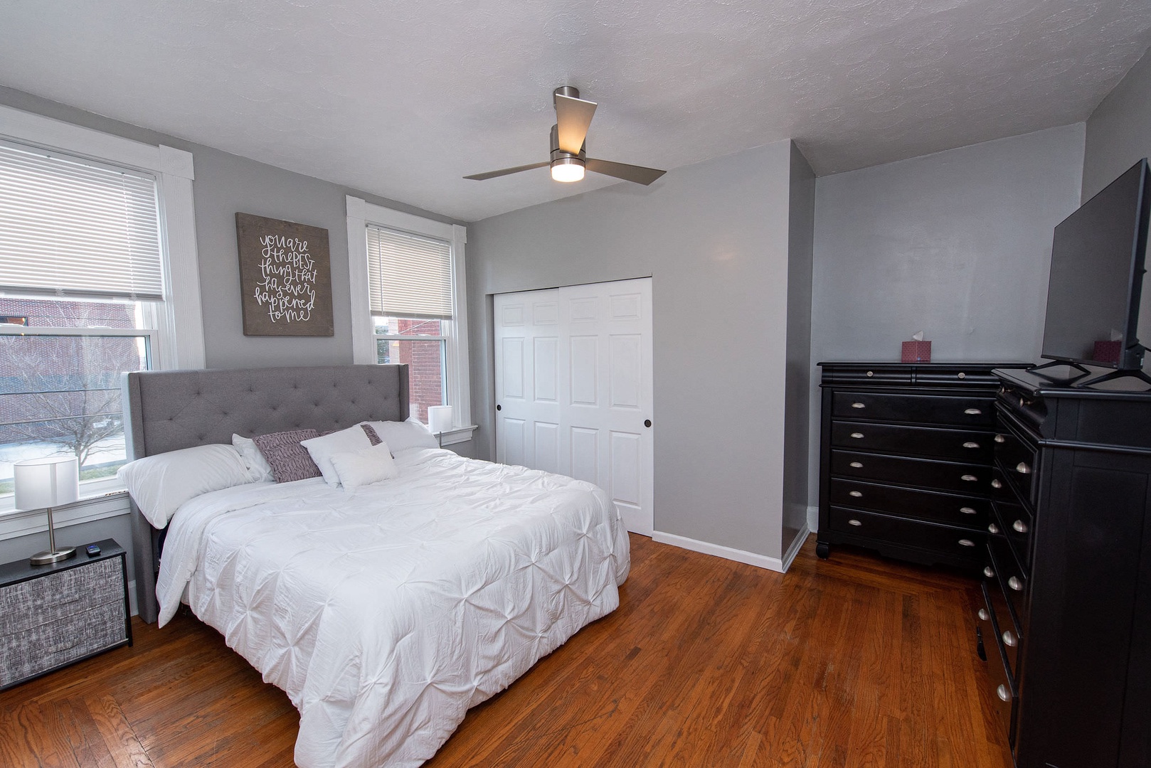 The primary bedroom includes a queen bed, Smart TV, & ceiling fan