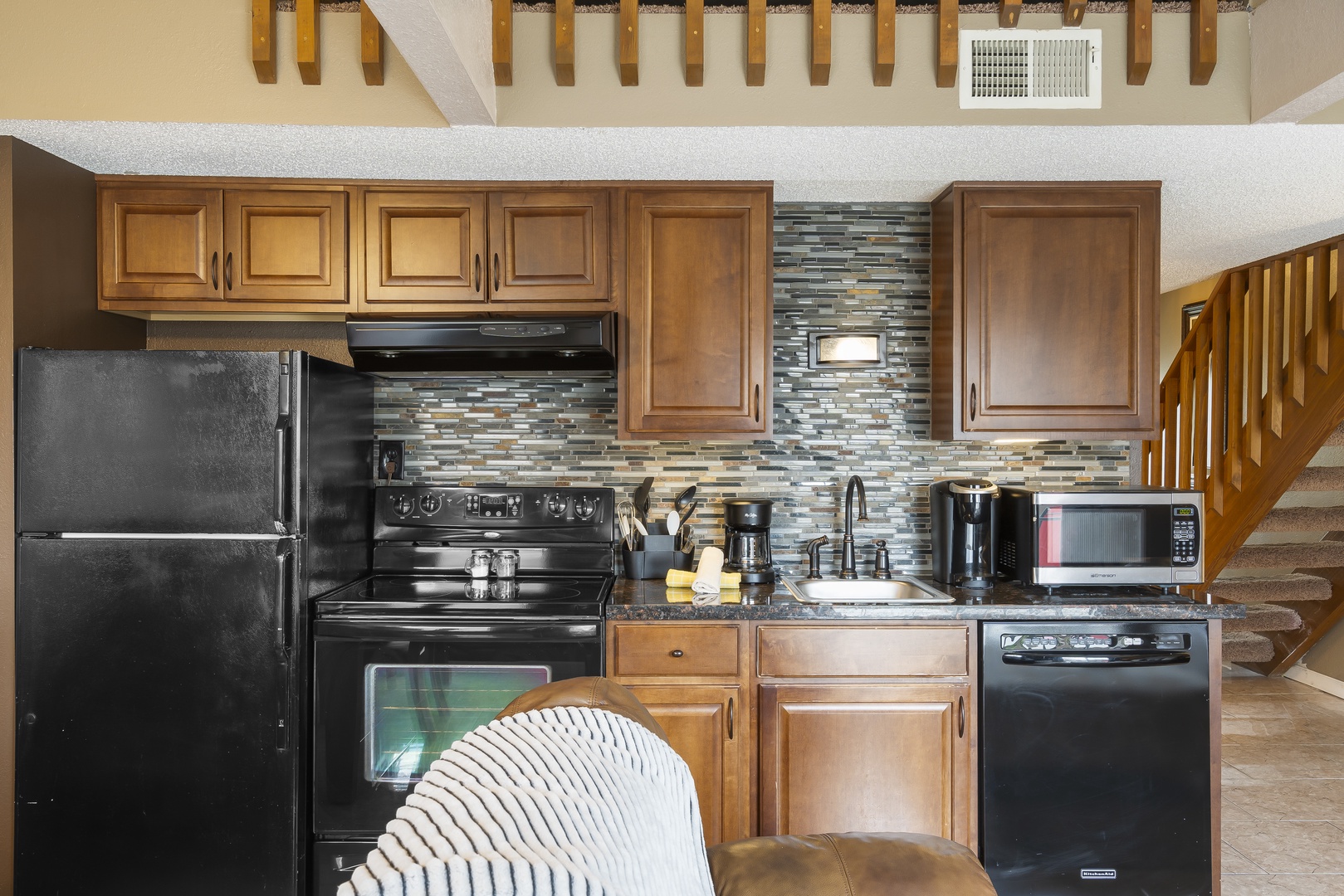 The sleek kitchen area offers ample space & all the comforts of home