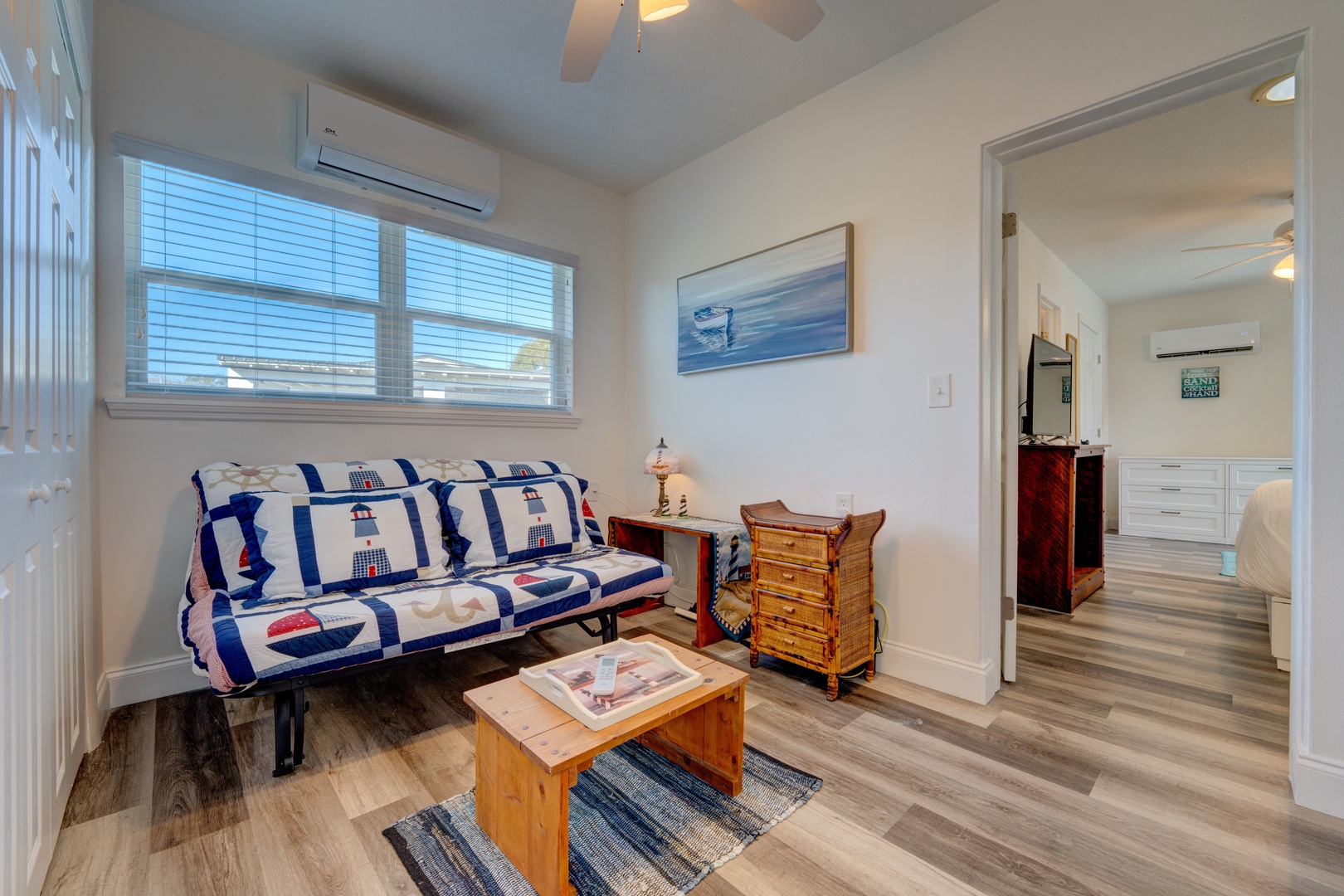 This bedroom features a cozy full-size futon & desk space & ceiling fan