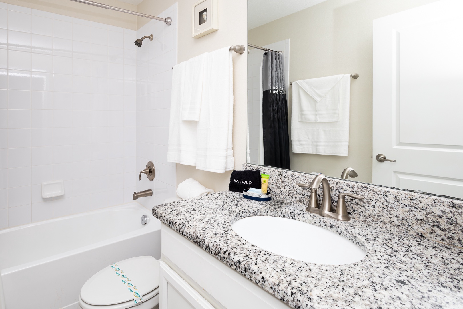 Shared bathroom with single vanity and  shower/tub combo