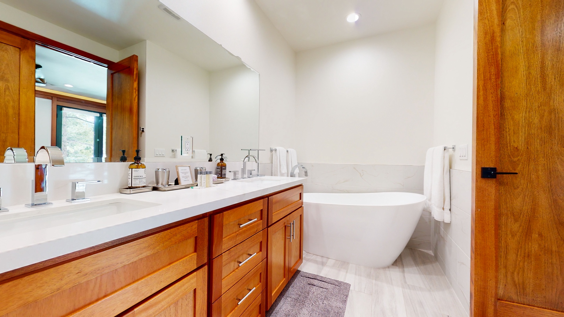The 3rd floor en suite boasts a sleek double vanity, glass shower, and soaking tub