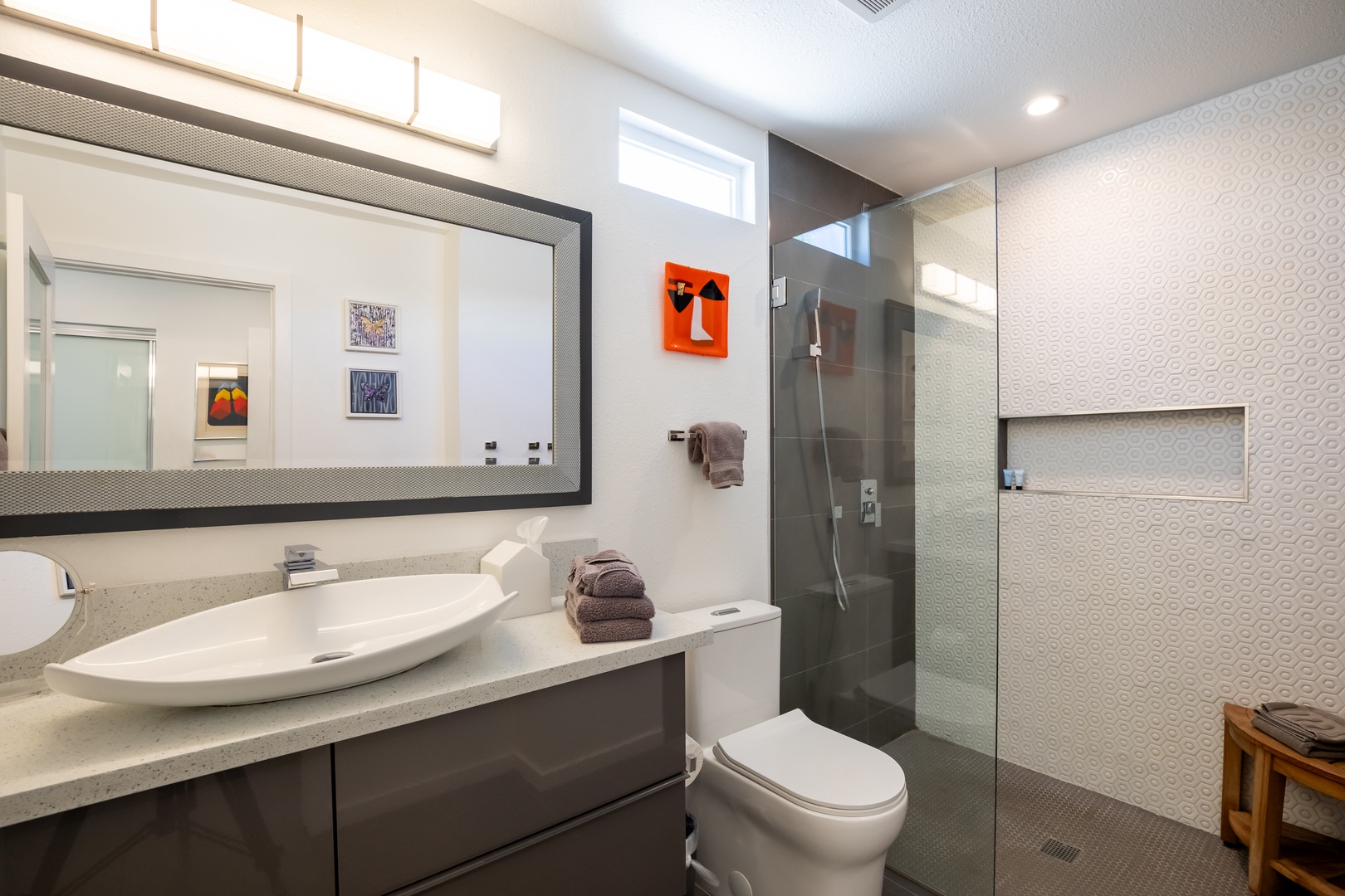 The polished primary king en suite boasts an oversized vanity & spa-like rain shower