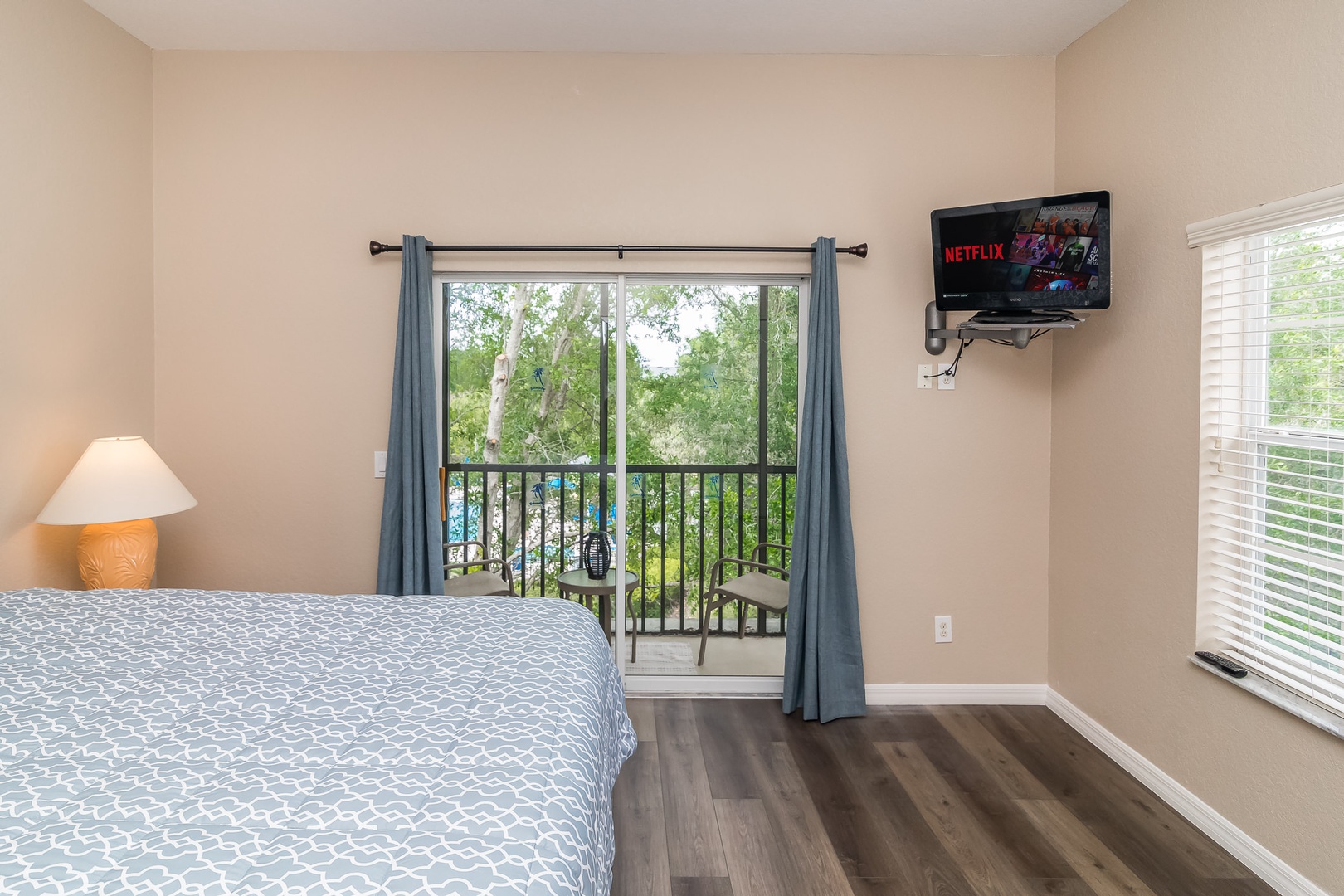 Bedroom 2 with Queen bed, Smart TV, screened balcony access, and Private en-suite