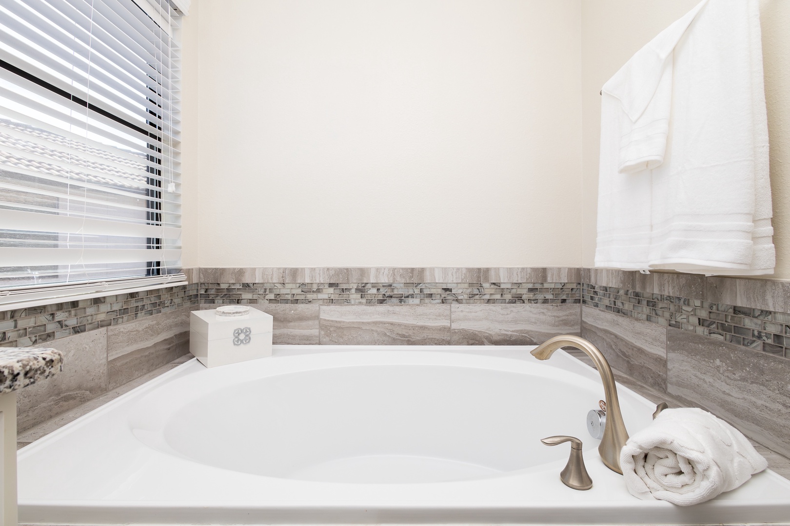 This ensuite bath features a double vanity, glass shower, and soaking tub