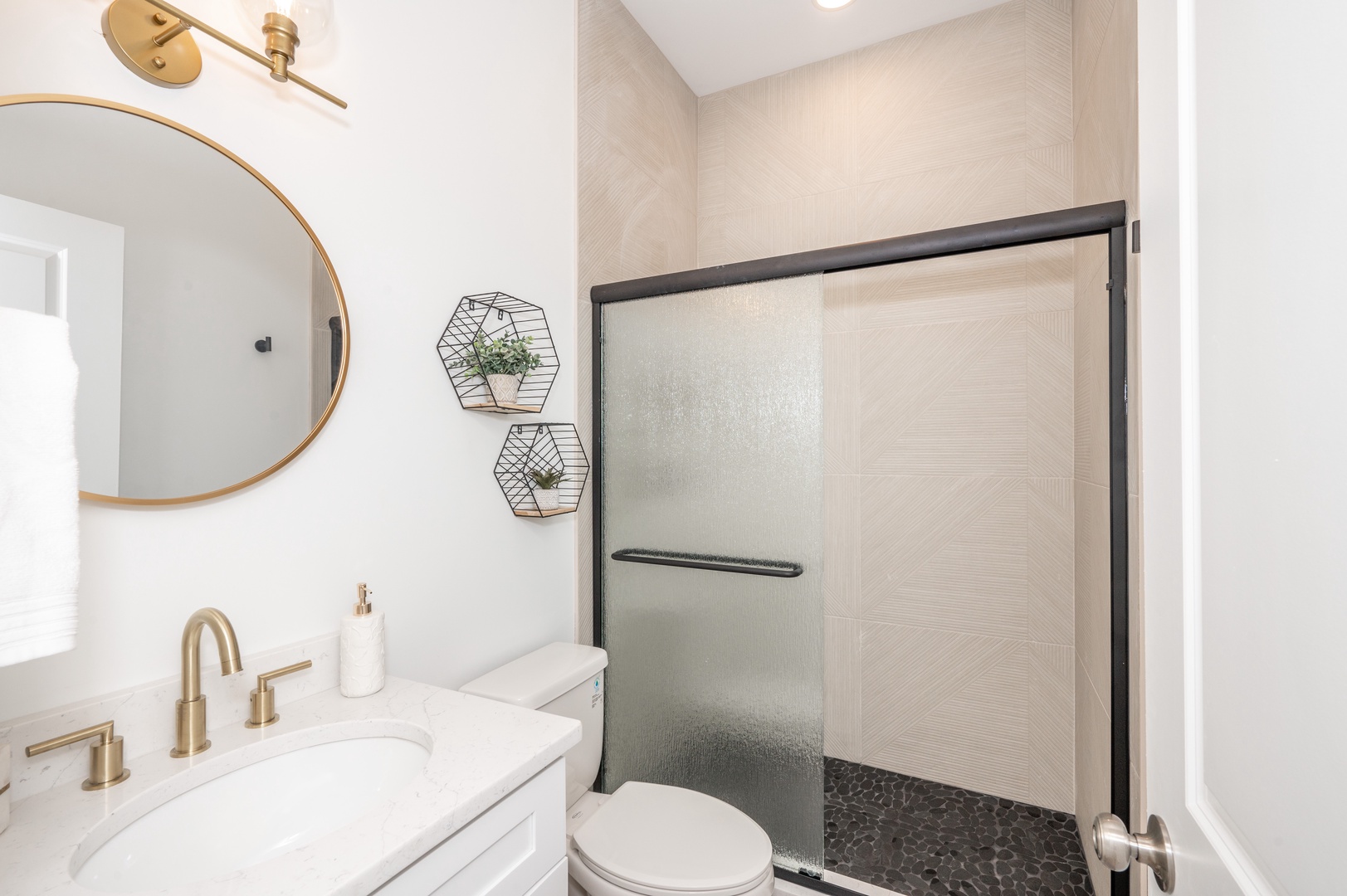 The bathroom offers a chic single vanity and spa-like glass shower