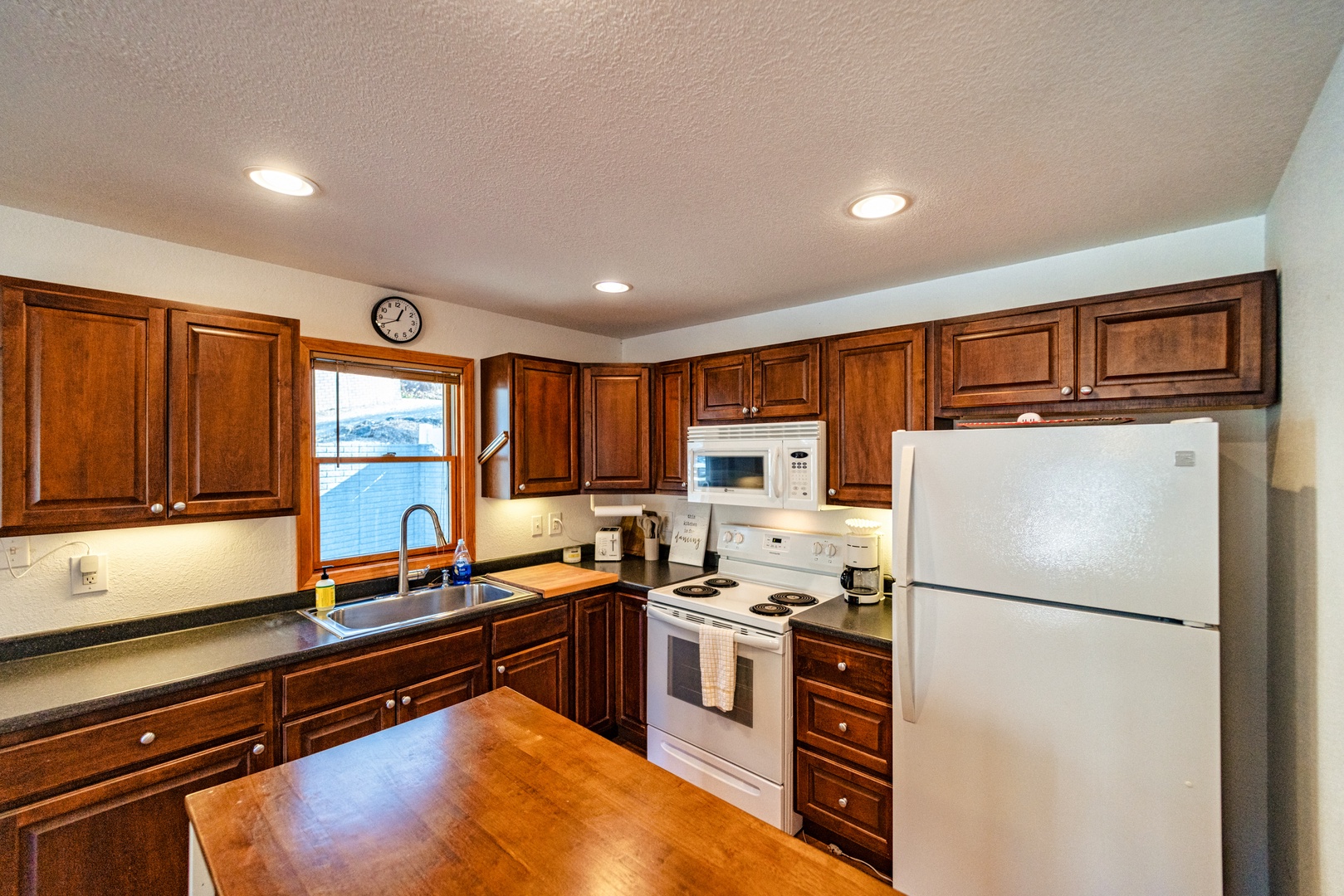 The cozy, open kitchen offers ample space & all the comforts of home