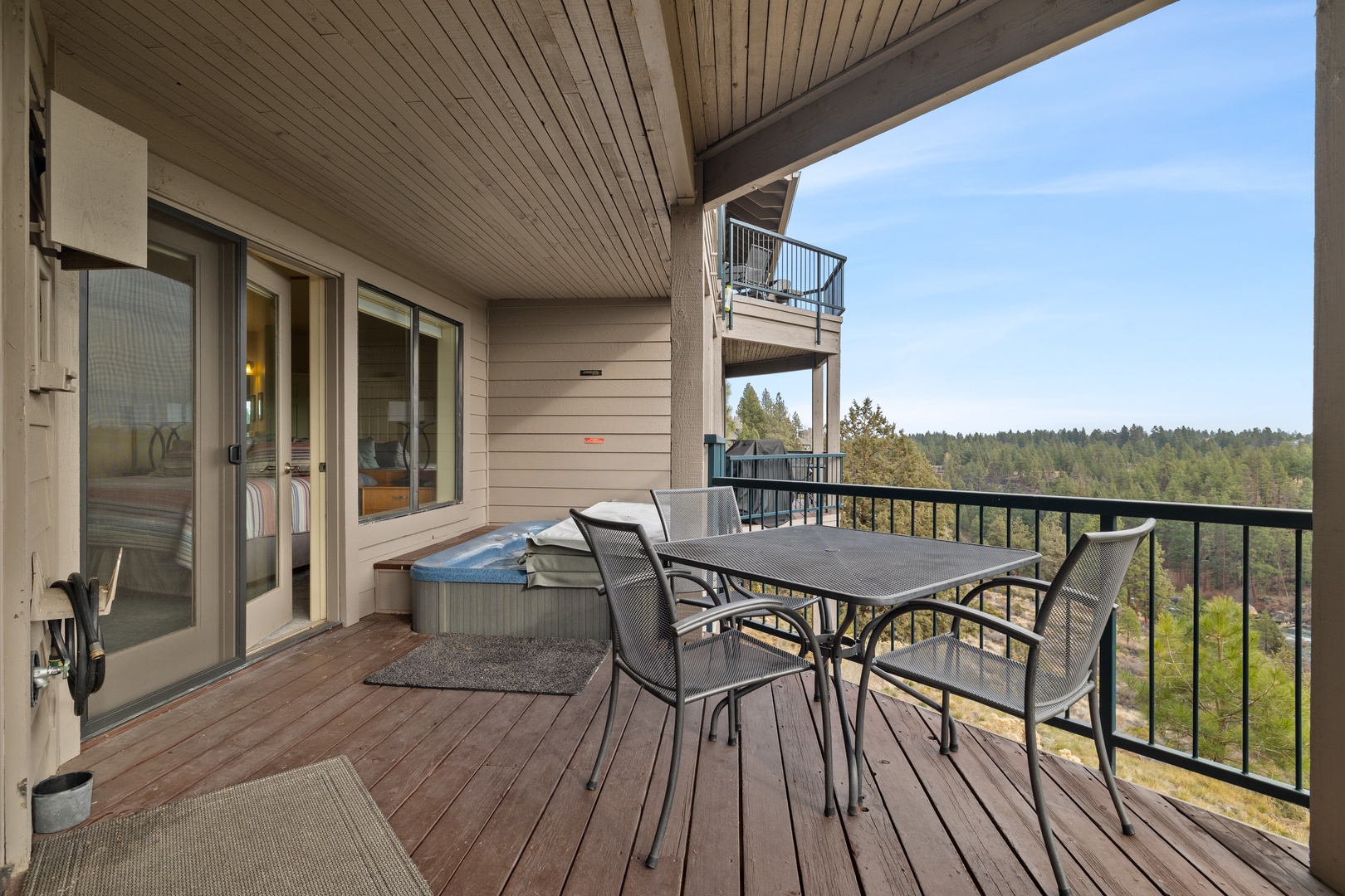 Spacious balcony with outdoor seating, grill, and hot tub