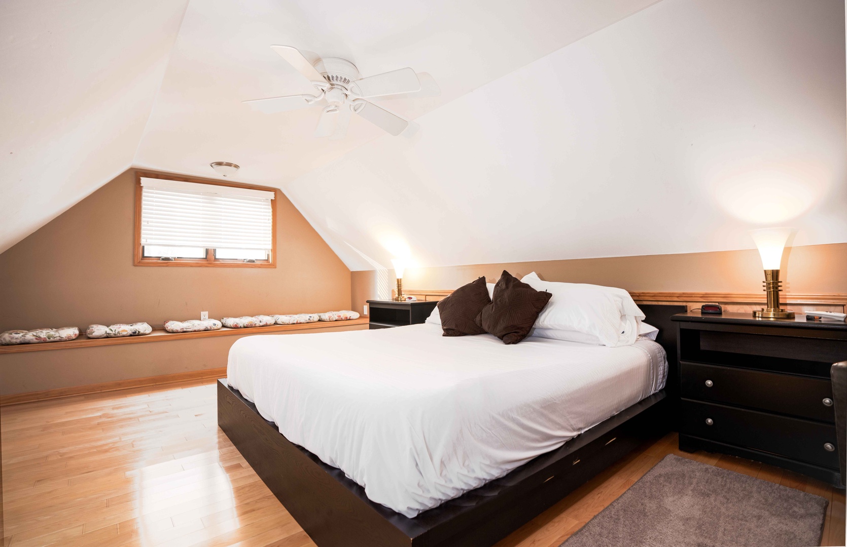 The guest house bedroom features a luxurious king bed & ceiling fan