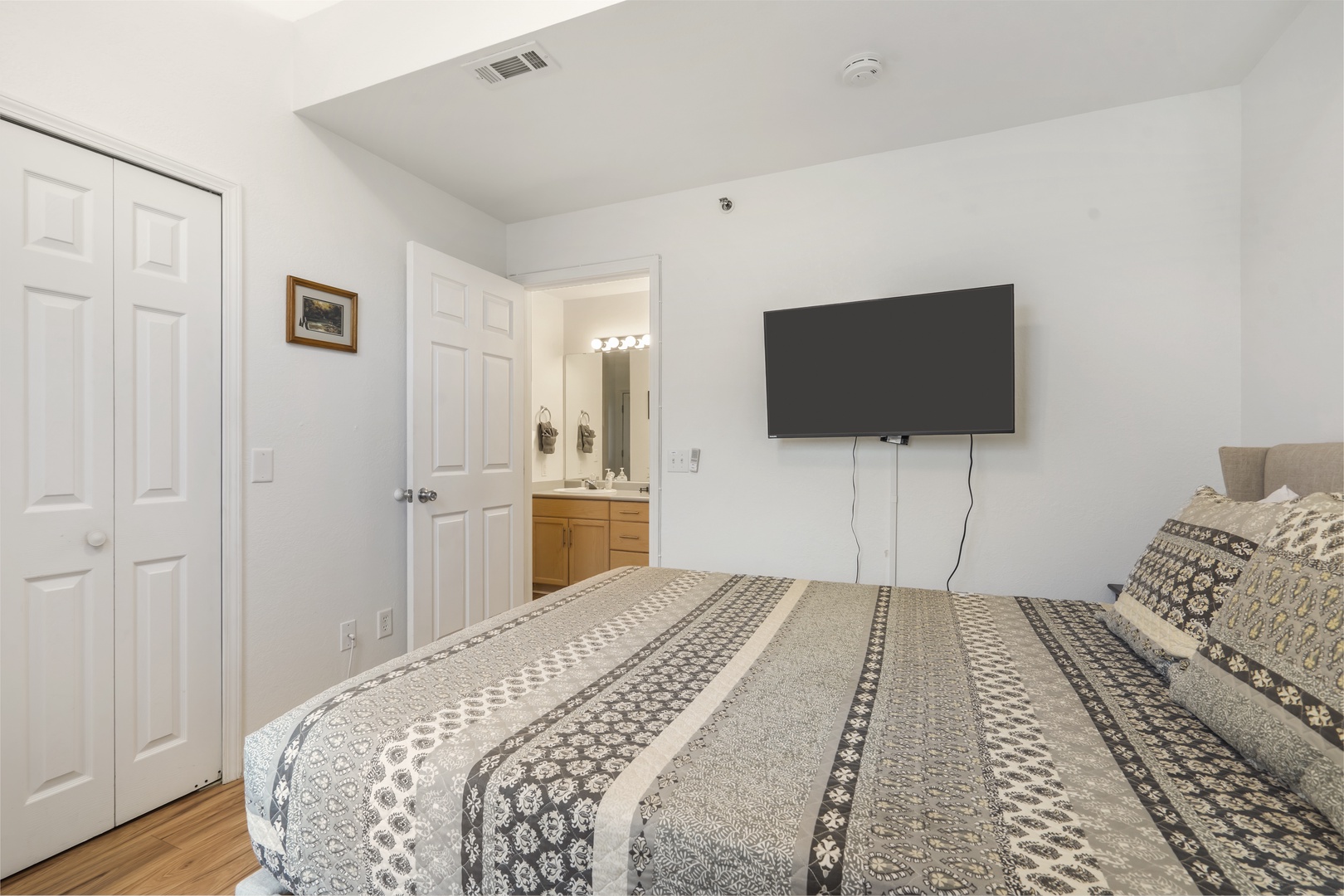 This main-level bedroom sanctuary includes a queen bed, TV, & ensuite