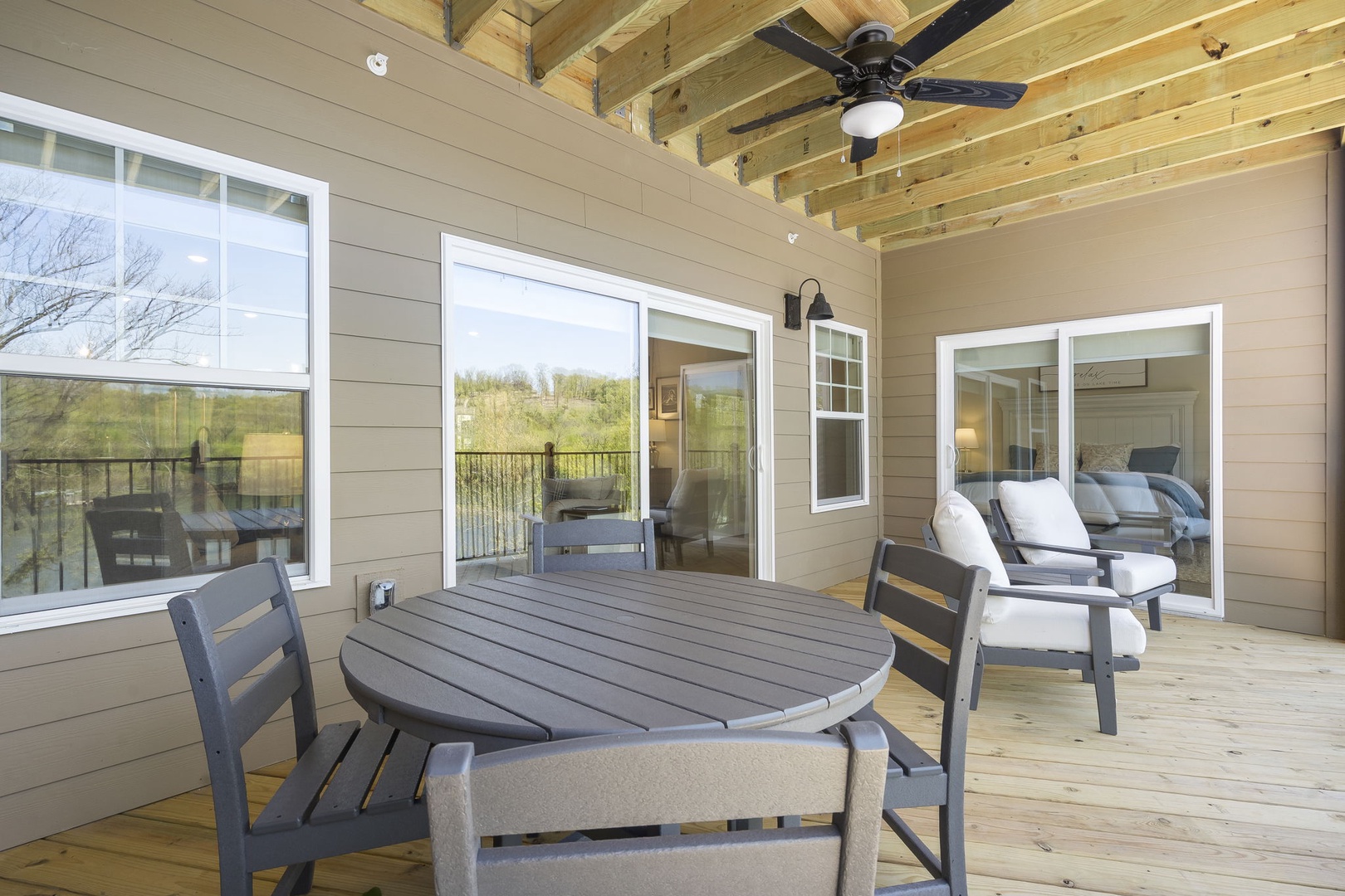 The covered back deck offers Outdoor Dining seating for 4 as well as extra spaces to lounge