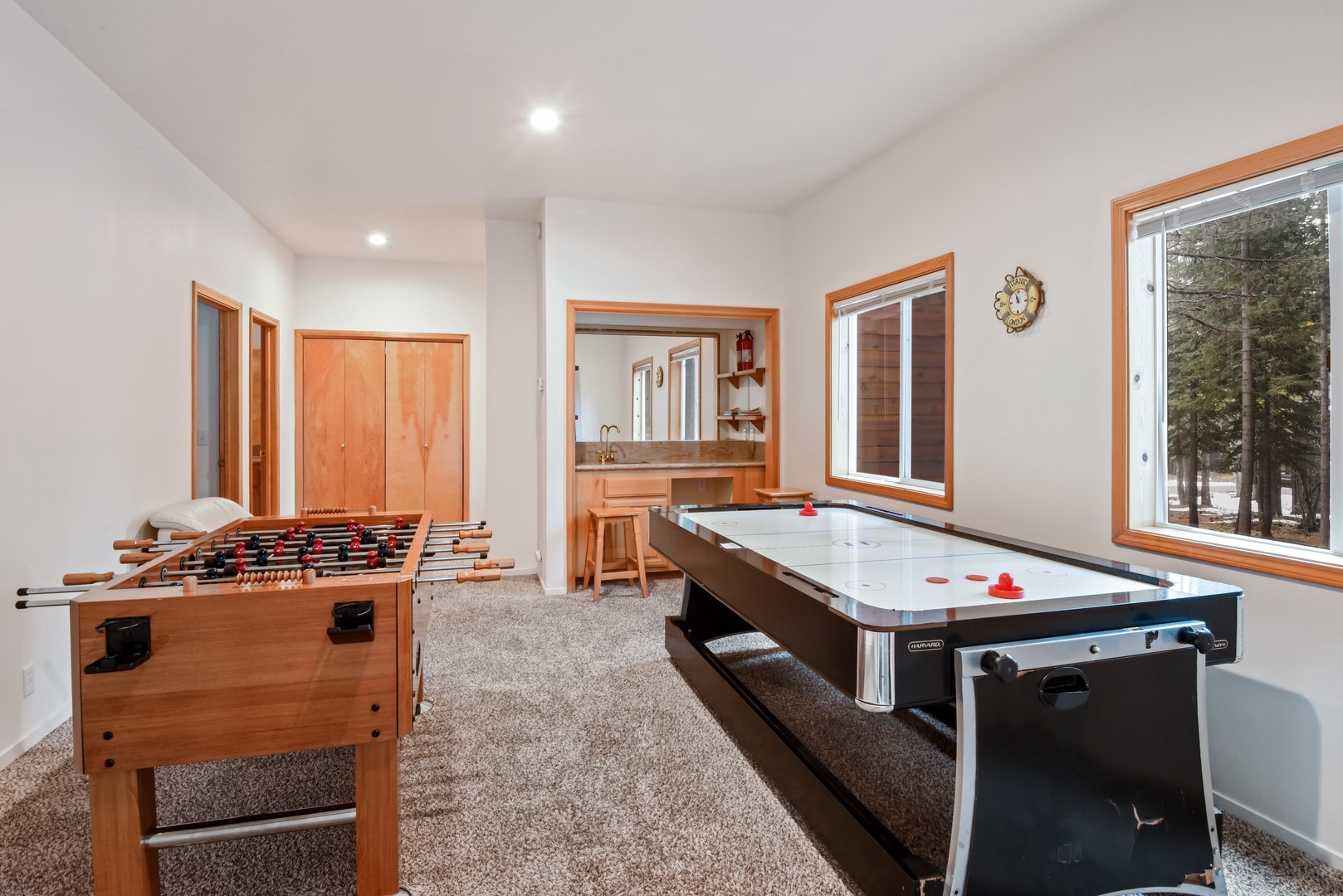 Game room with air hockey, fooseball table, and wet bar