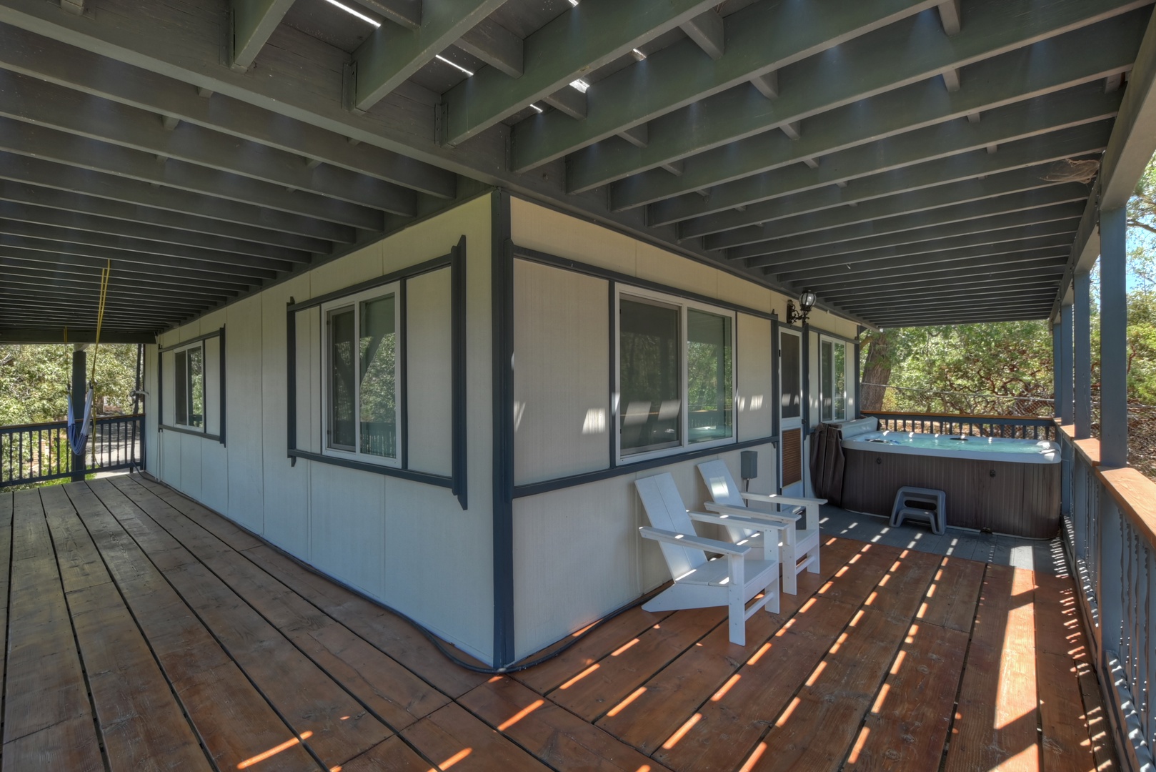 Deck with hot tub, seating, and hammock