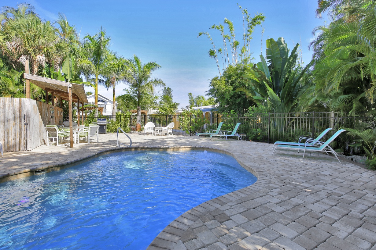 Tropical patio with outdoor seating, pool, and BBQ