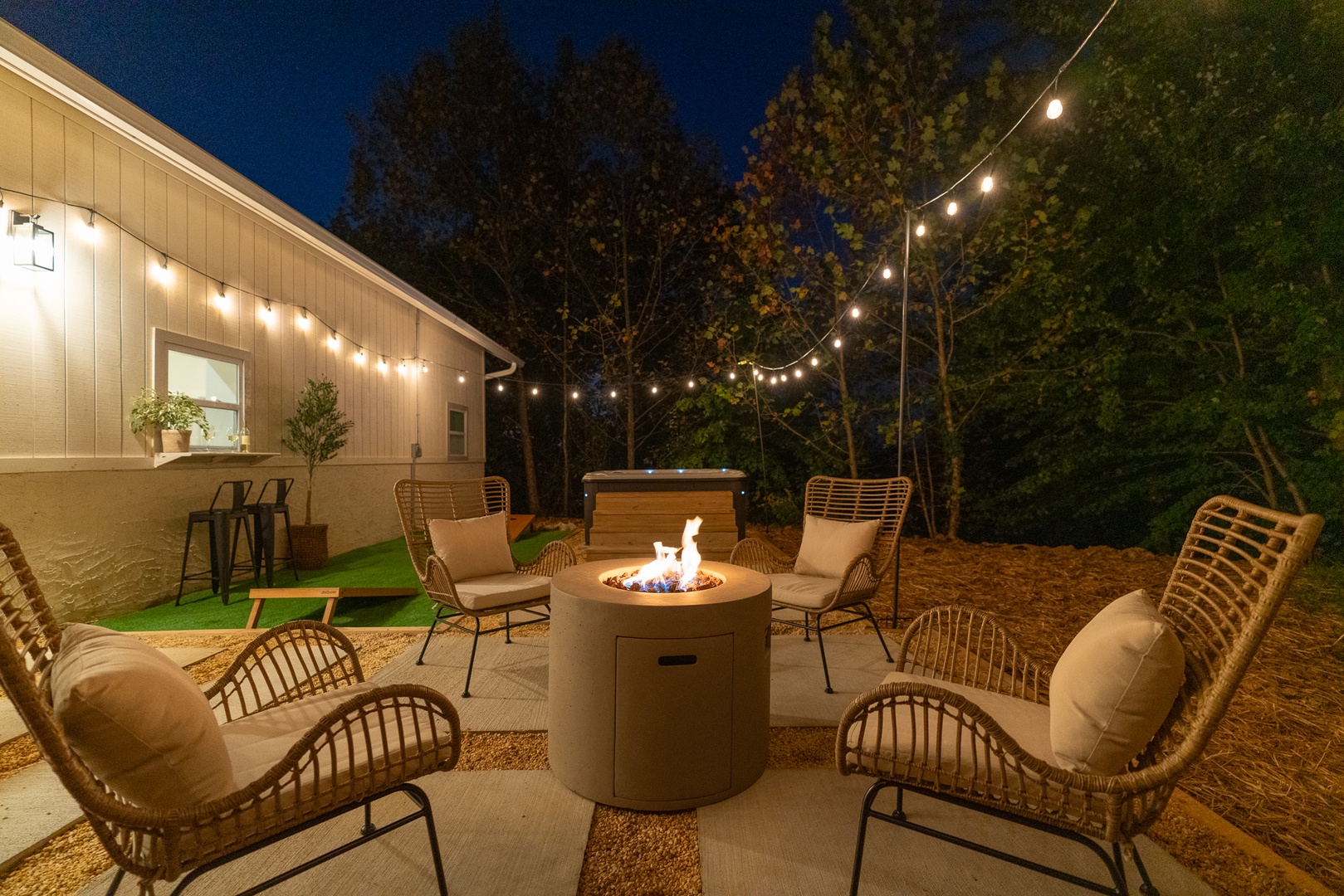 Backyard oasis with firepit, hot tub, bar seating, and cornhole for fun evenings