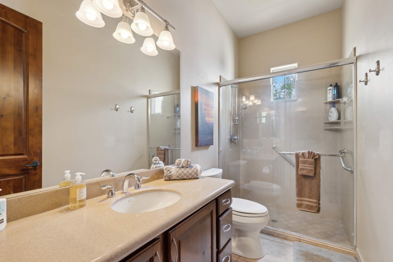 Shared full bathroom offers a single vanity & glass shower