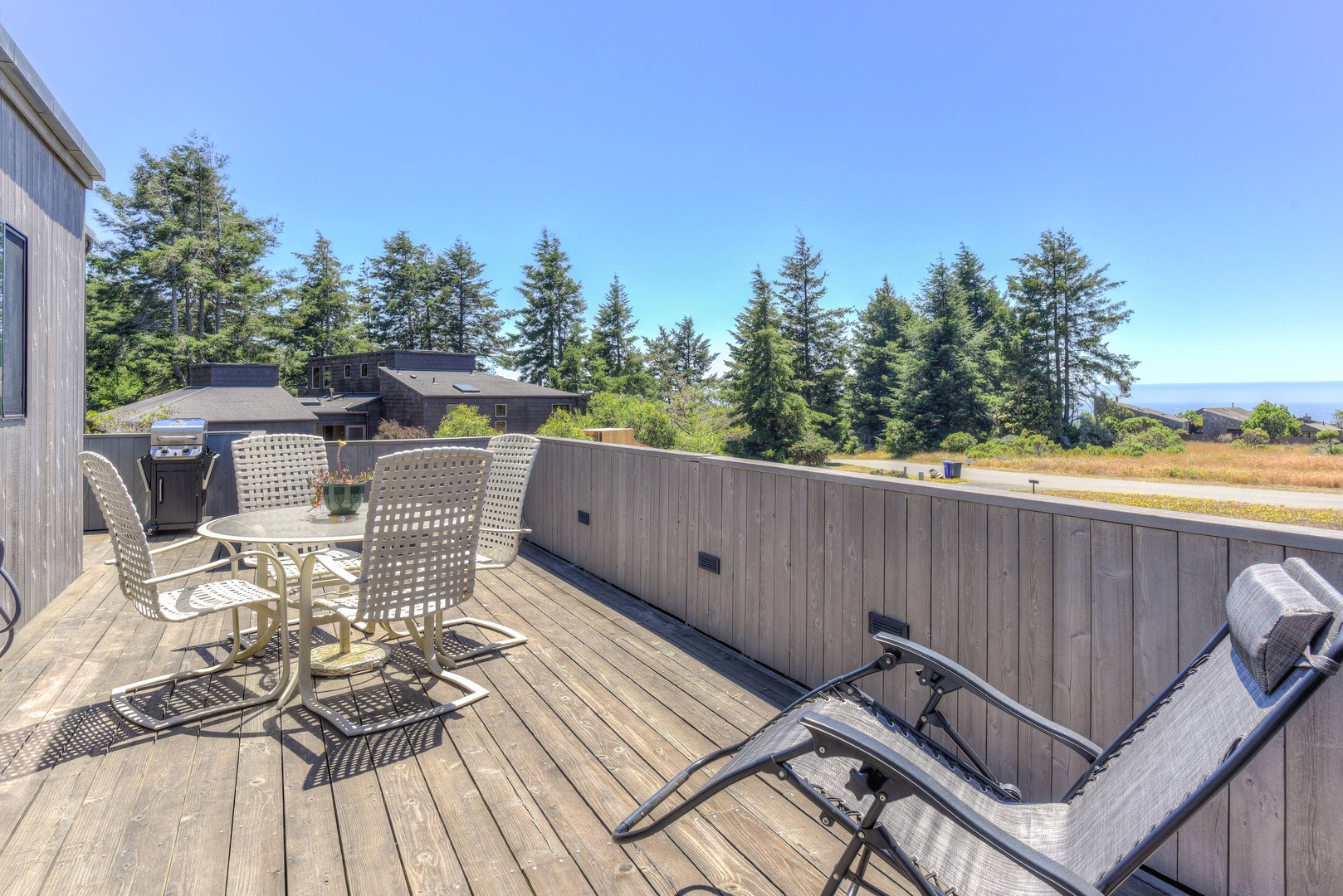 Deck with BBQ, seating, hot tub, and ocean views