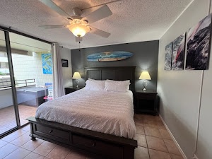 Bedroom 1 with King bed, lanai access, TV, and en-suite